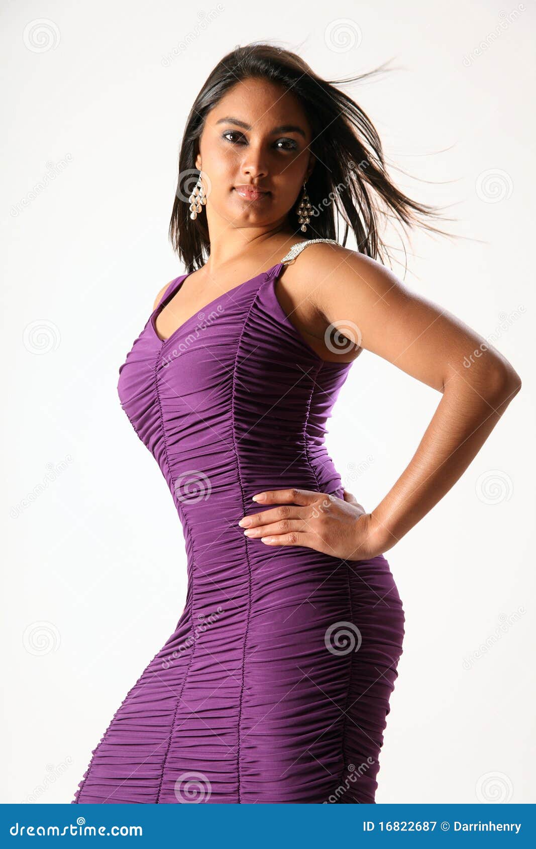 Modello di modo femminile Voluptuous in vestito viola. Bello e giovane modello di modo voluptuous che propone nello studio che porta figura viola che abbraccia vestito.