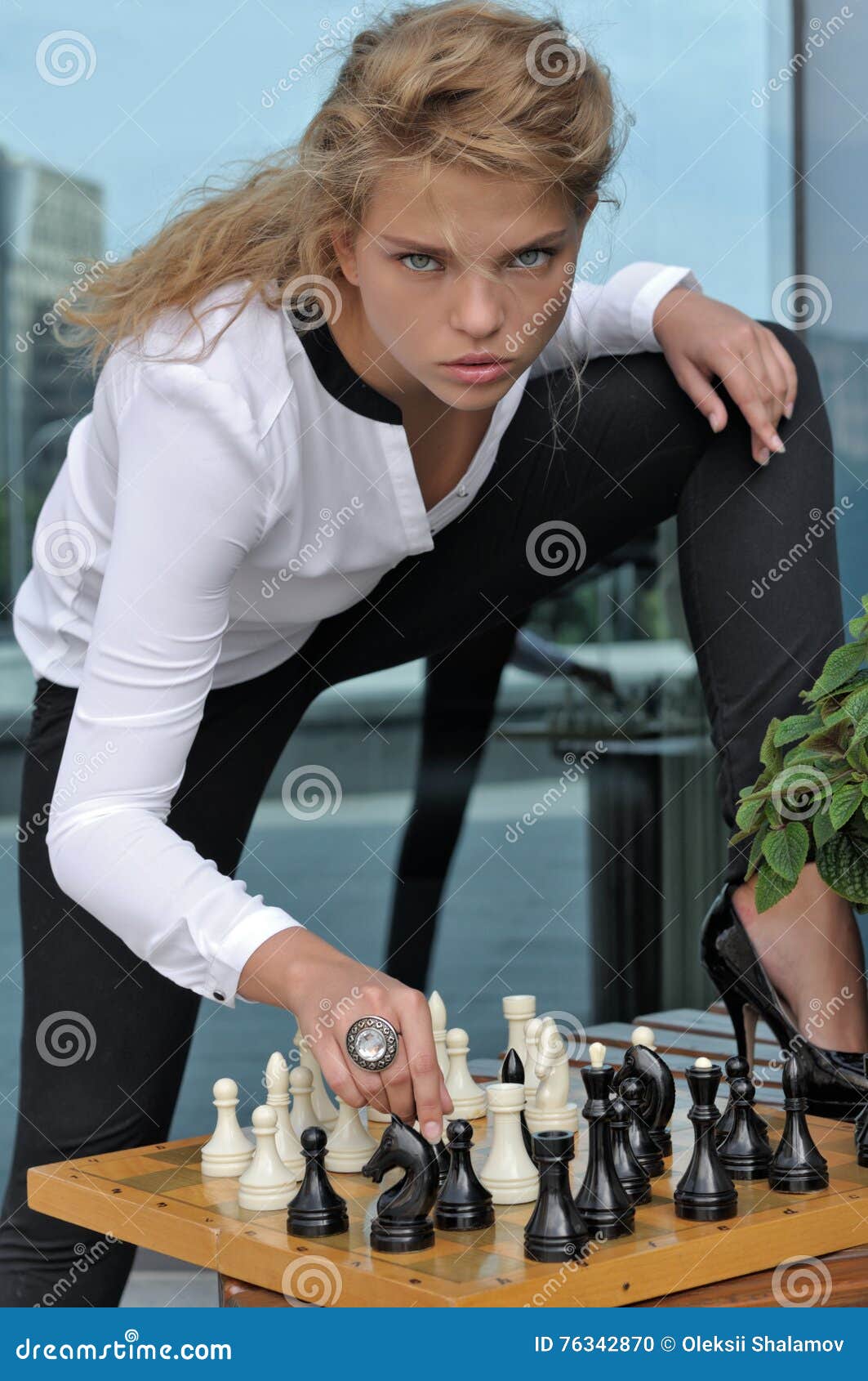 um cara de pele escura senta e pensa em um tabuleiro de xadrez