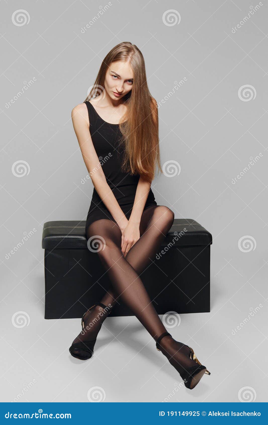 Serrado deuda Torbellino Modelo Delgado En Vestido Negro Corto Y Piernas Largas En Medias De  Pantilla Sentadas En Caja De Cuero Imagen de archivo - Imagen de elegante,  fondo: 191149925