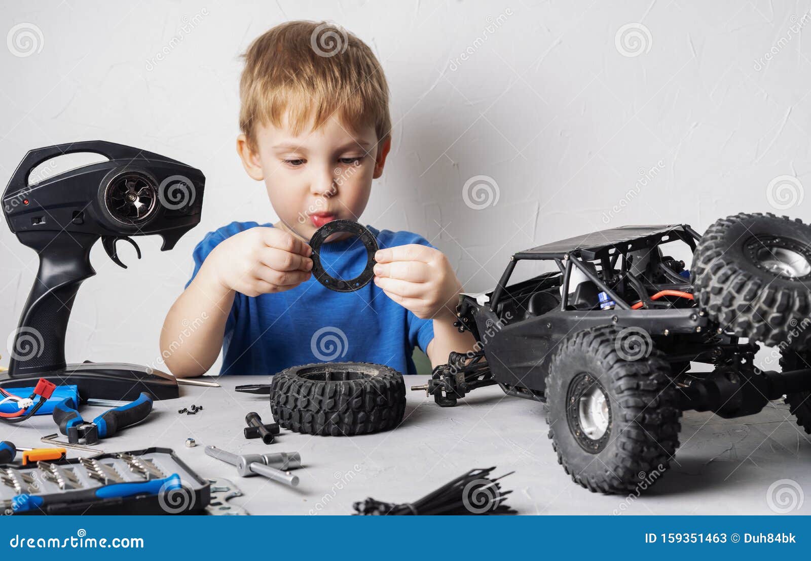 Modelos Con Control De Radio: Un Niñito Con Una Camiseta Azul Está Reparando Su Vagón RC. Imagen de archivo - Imagen de vagón, reparando: 159351463