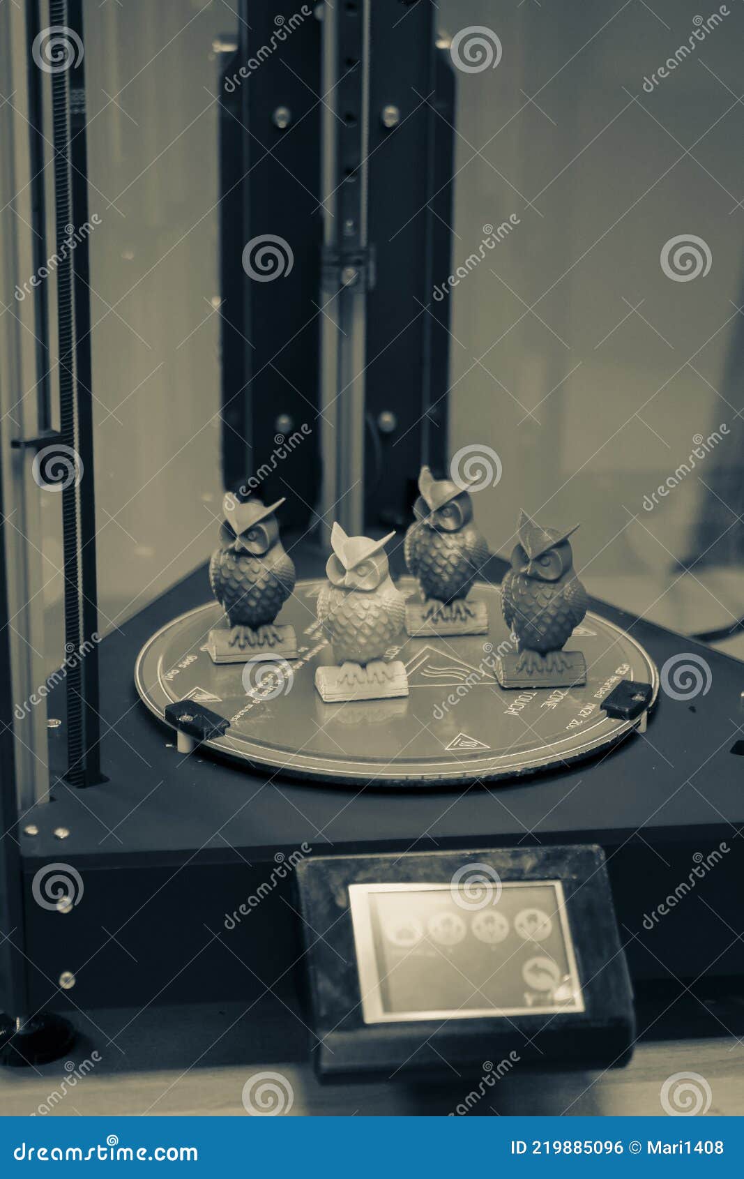models in the form of owls stand inside a three-axis 3d printer