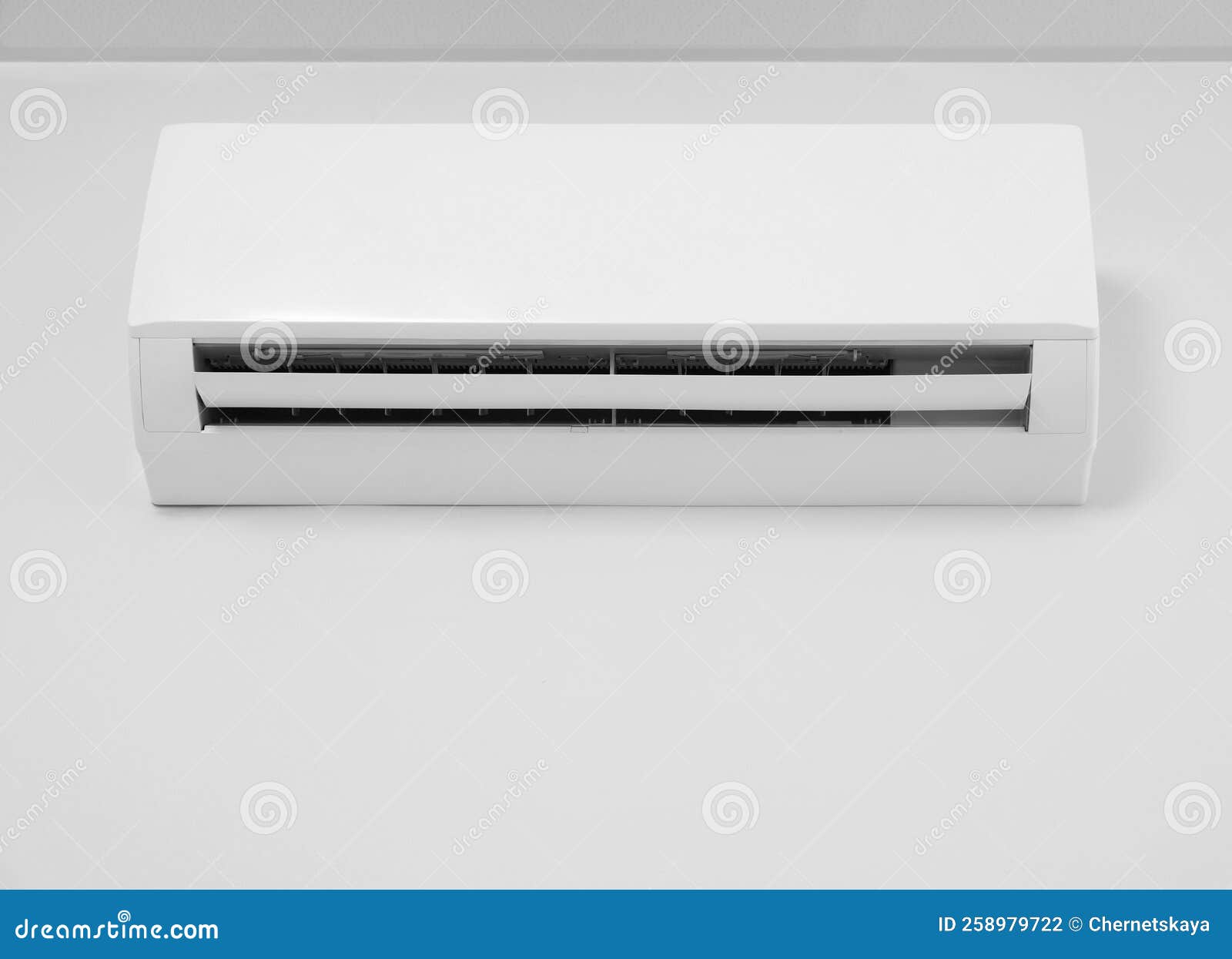 Modern Air Conditioner on White Wall Indoors, Low Angle View Stock