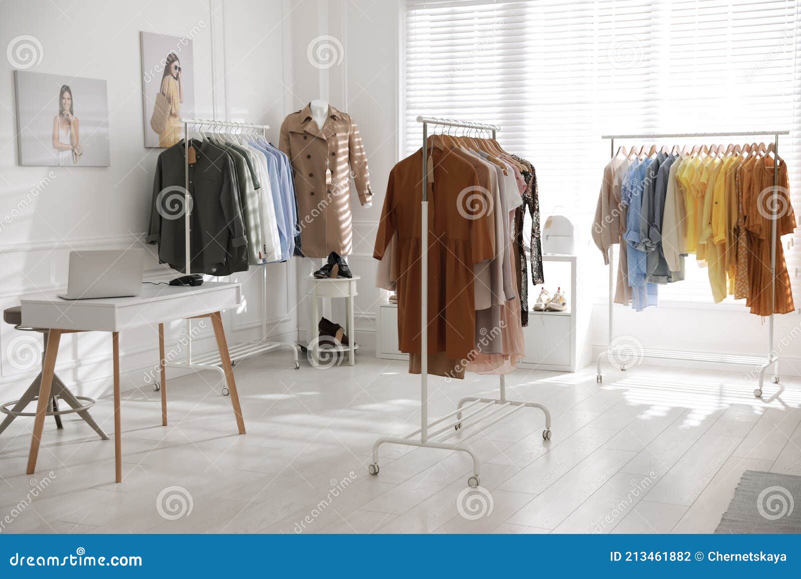 modern boutique interior with stylish clothes and laptop