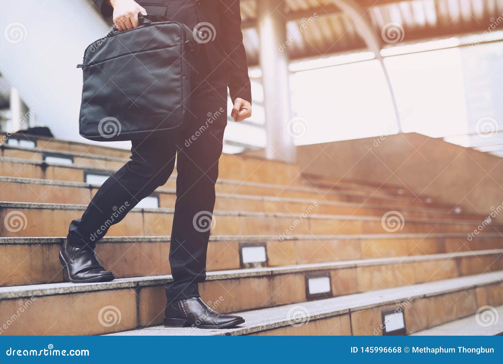 modern businessman hand holding briefcase computer notebook beside working close up legs