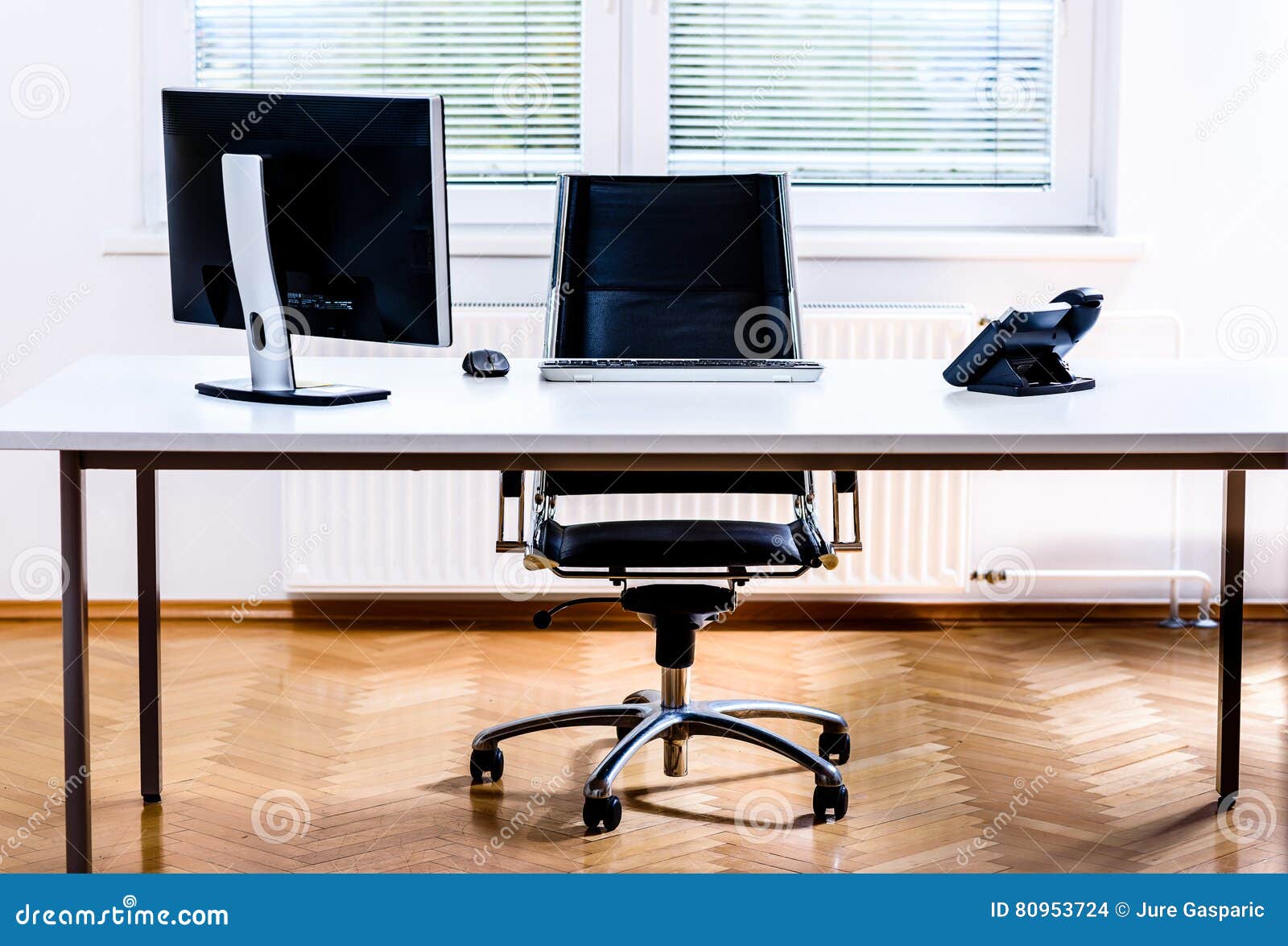 modern empty office space desk with computer, phone and chair.