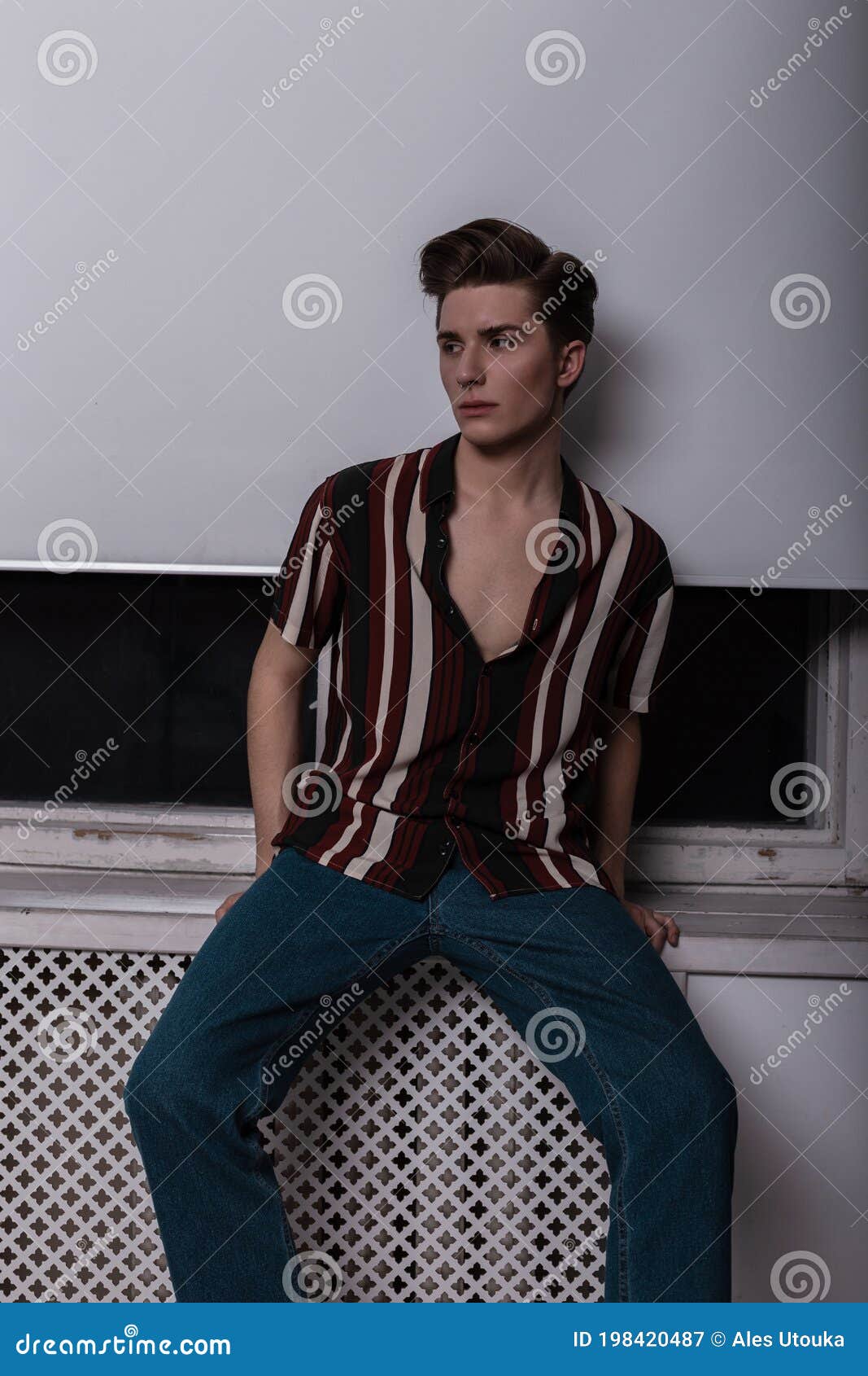 Modern Fashion Model of Fashionable Young Man with Stylish Hairstyle in  Trendy Clothes in Retro Style Posing Near a White Window Stock Image -  Image of piercing, attractive: 198420487