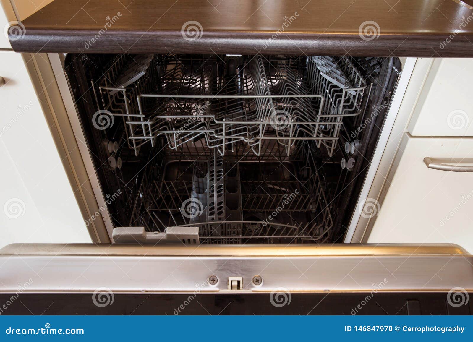 Modern Half Open Empty Dishwasher in a Modern Kitchen Stock Photo