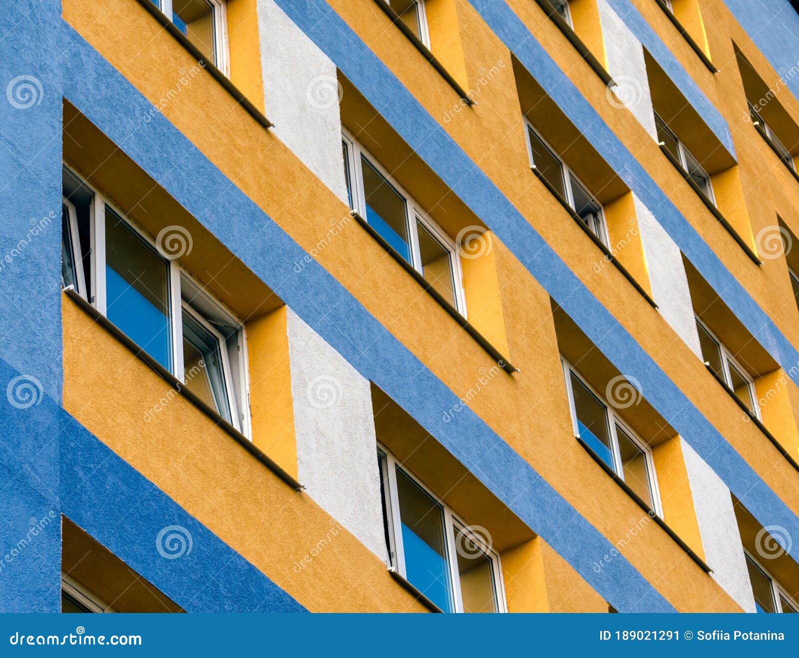Modern House with Yellow and Blue Walls and Empty Windows Stock Image