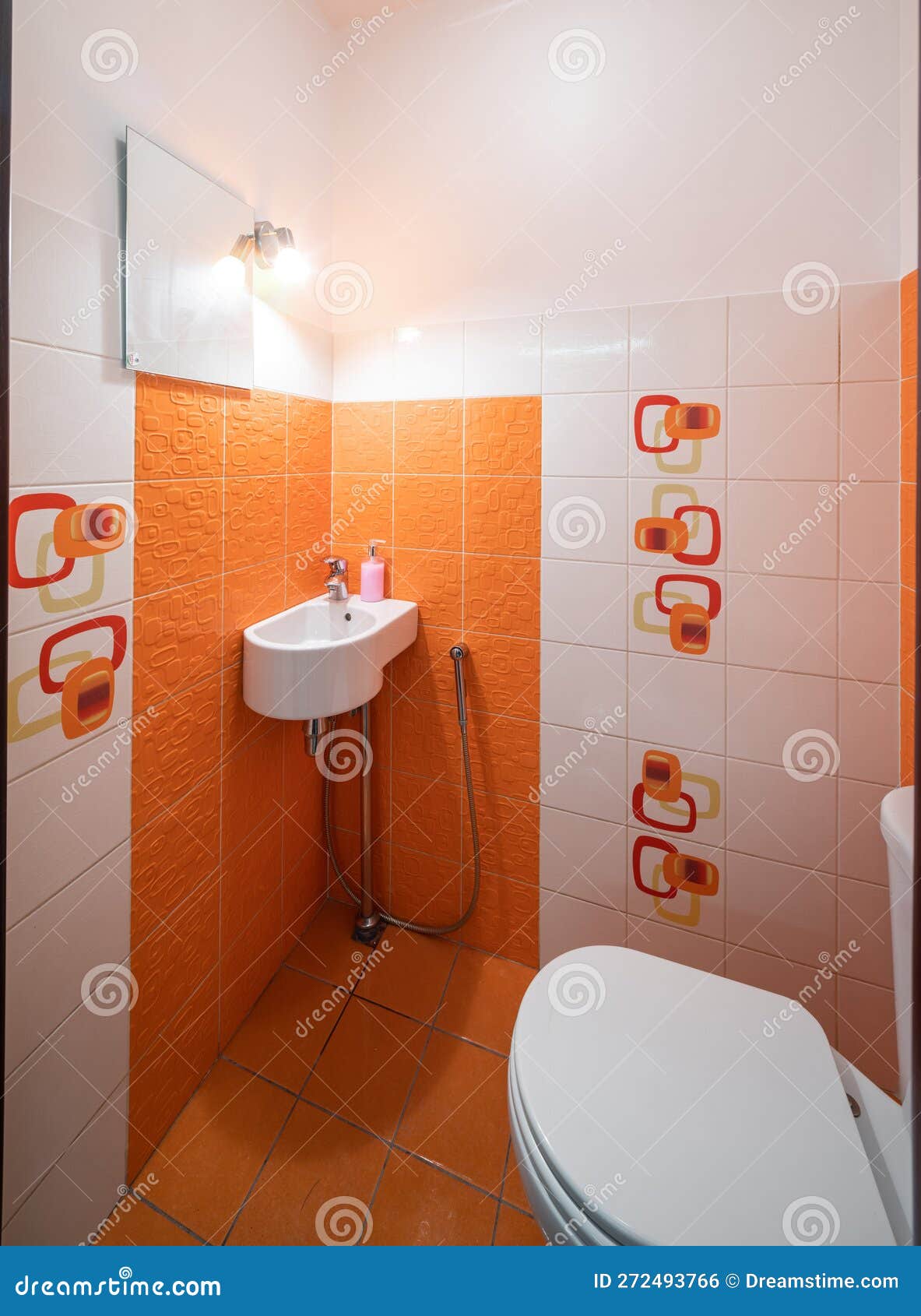 Modern Interior of Bathroom. Orange Tile. Sink and Toilet. Stock Photo