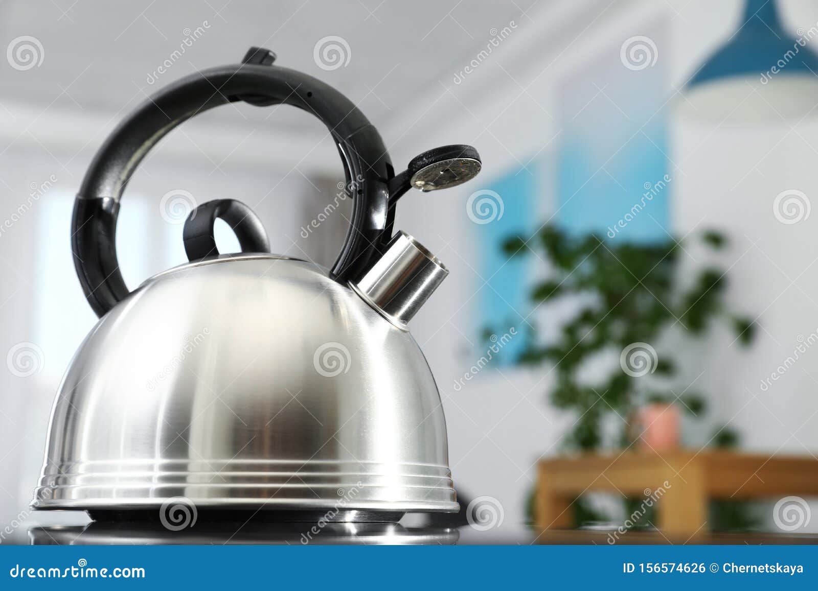 Modern Kettle with Whistle on Stove in Kitchen, for Text Stock Photo