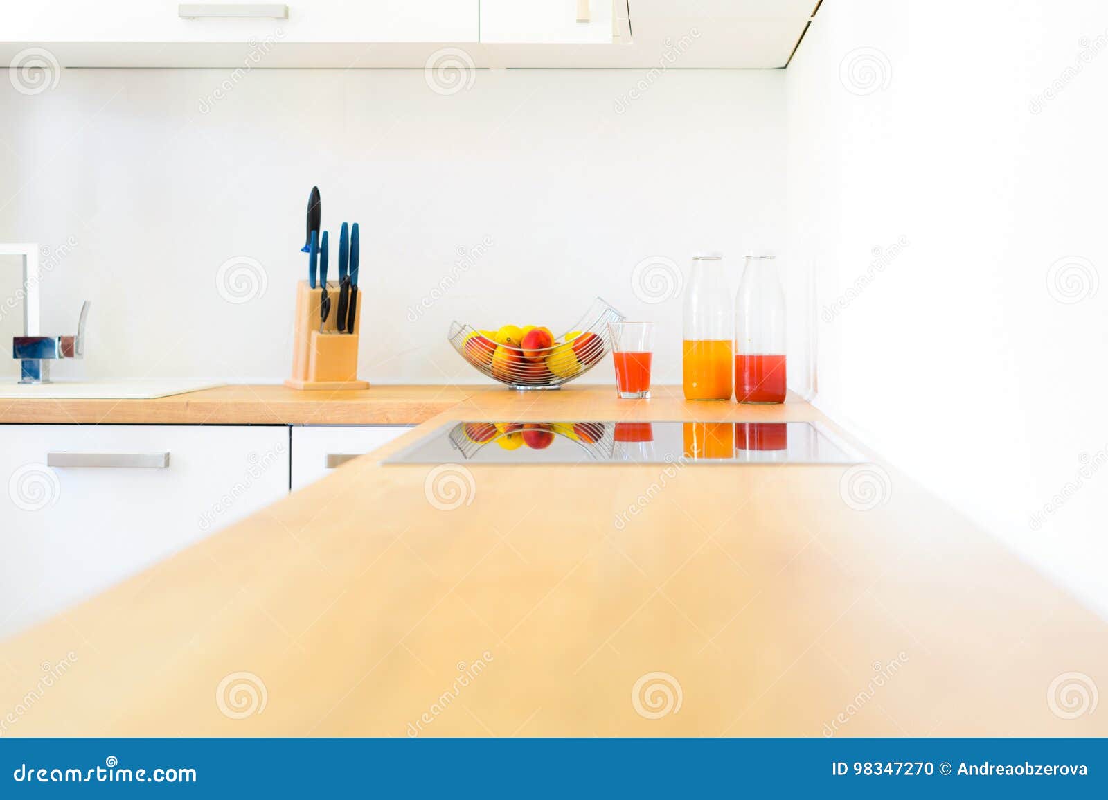 modern kitchen counter with induction hob, fresh fruit and homemade lemonade