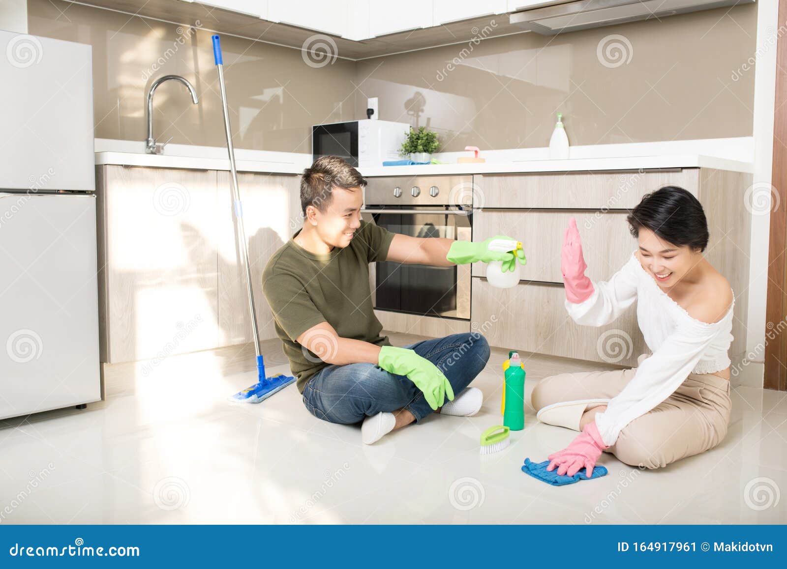 Modern Kitchen Smiling Young Asian Woman And Man Cleaning The Floor