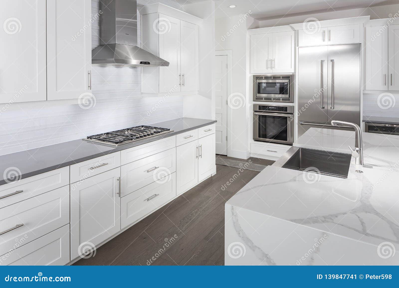 Modern Kitchen With White Cabinets And Stainless Appliances Stock