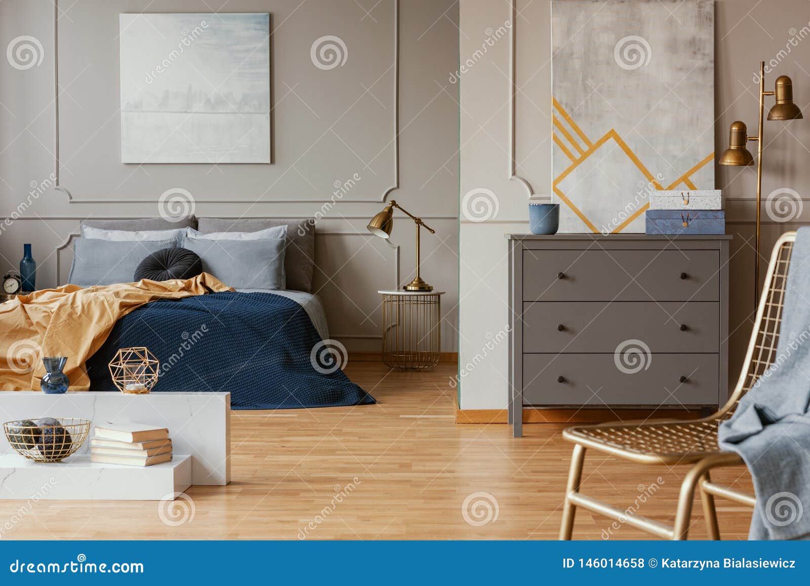 Lamp on Nightstand Table Next To King Size Bed in Grey Bedroom Interior