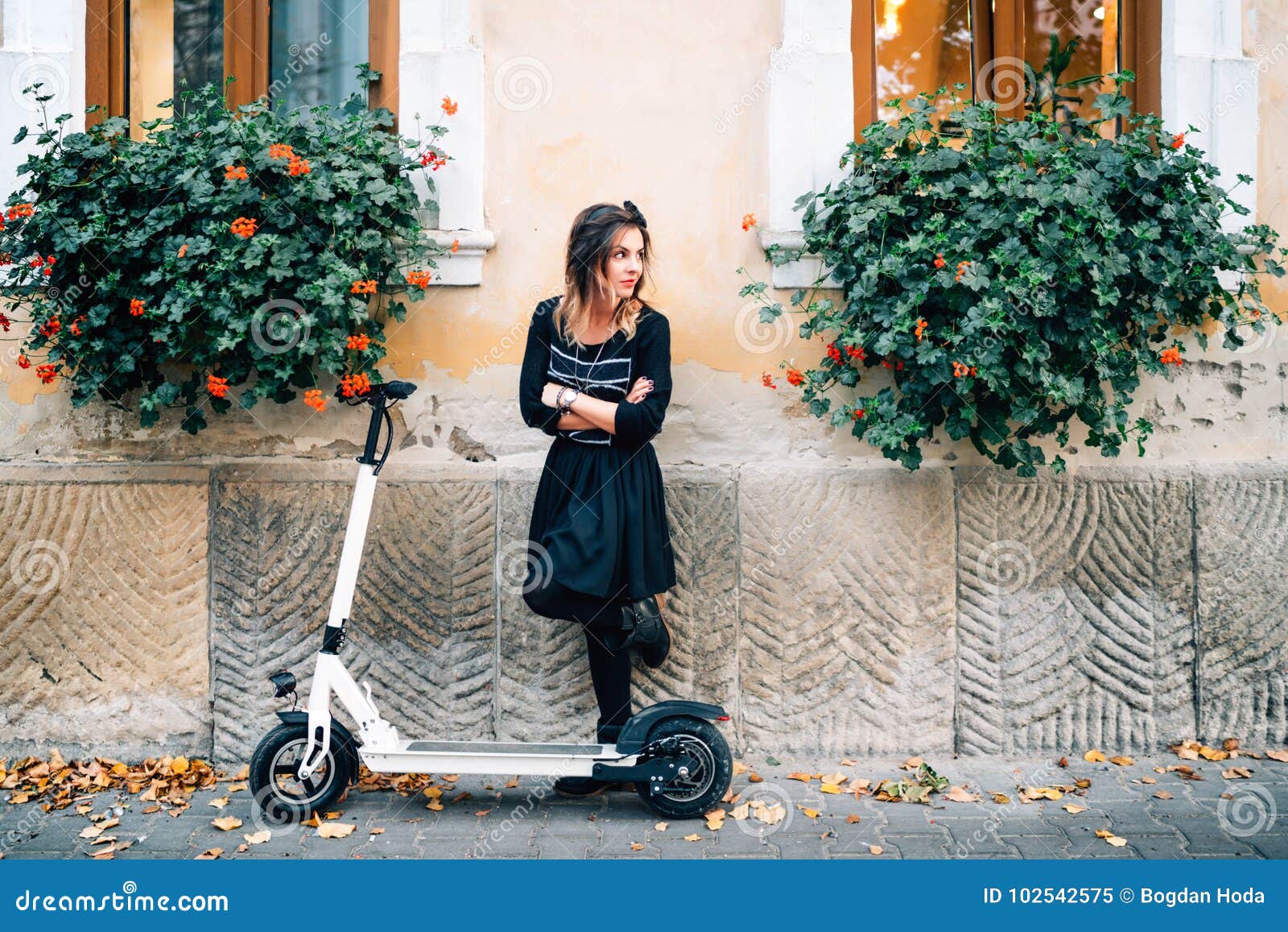 lifestyle details, happy girl with flowers in urban city enjoying the electric scooter. happiness and carefree concept