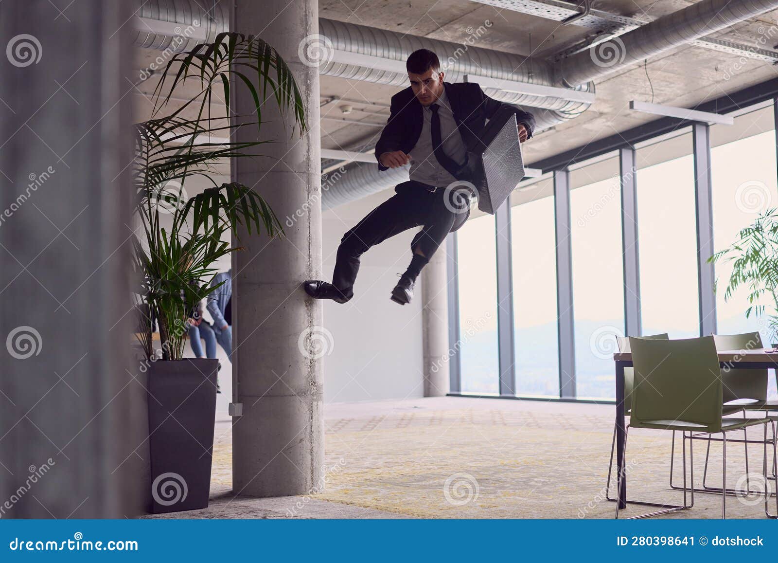 in the modern office, a businessman with a briefcase captivates everyone as he performs thrilling aerial acrobatics