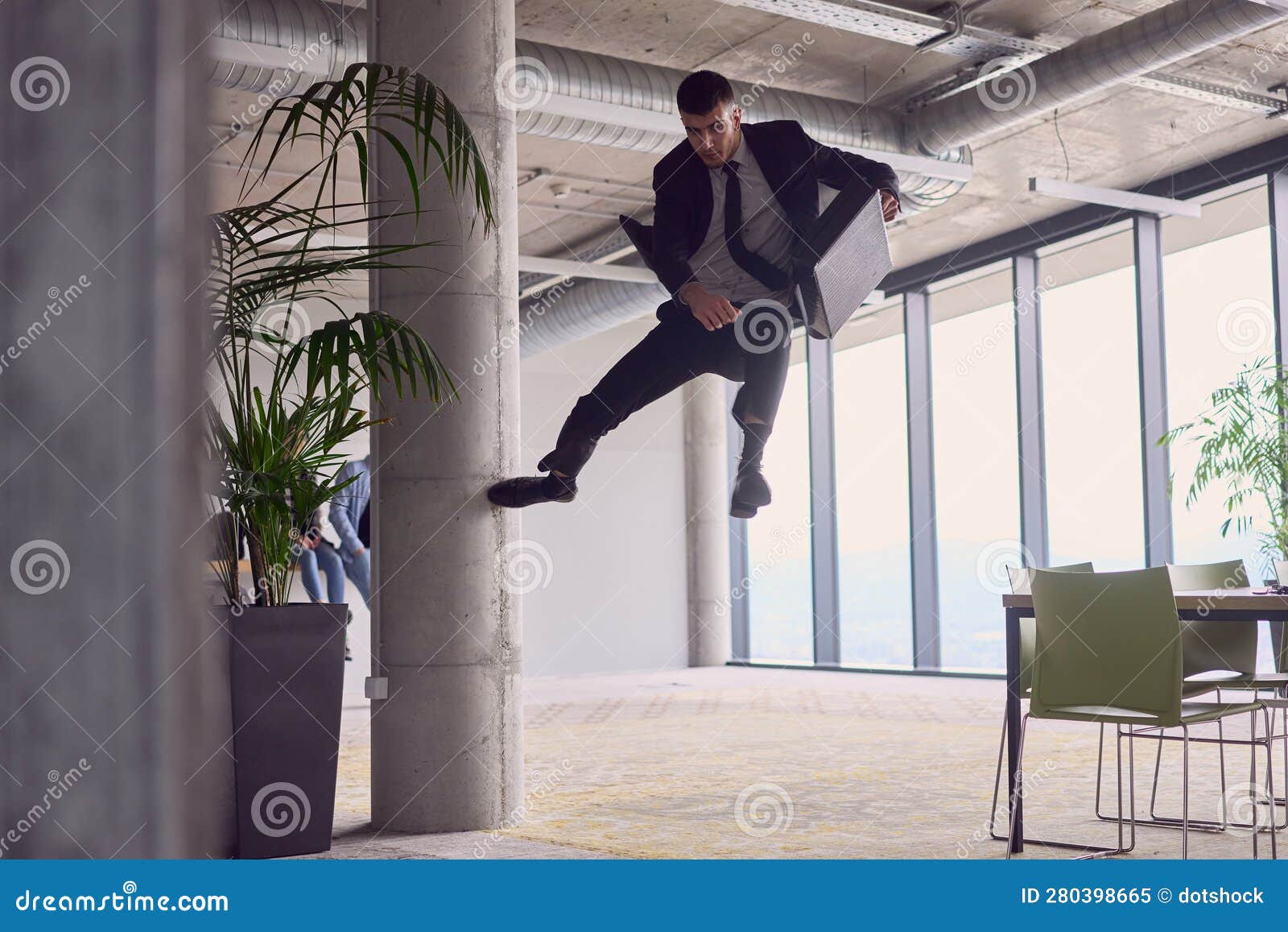 in the modern office, a businessman with a briefcase captivates everyone as he performs thrilling aerial acrobatics