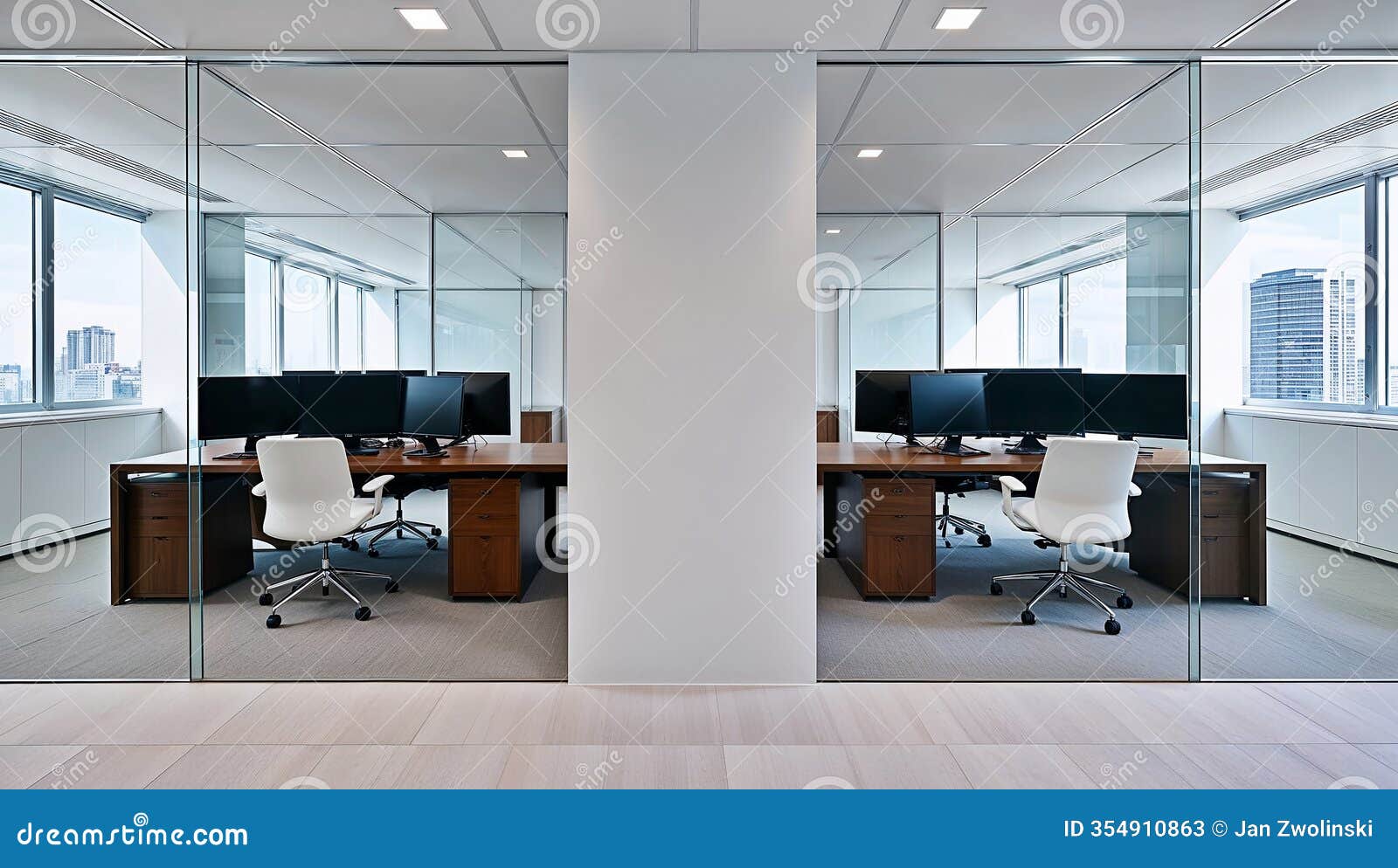 modern office interior showing desks and computers in glass partitioned room