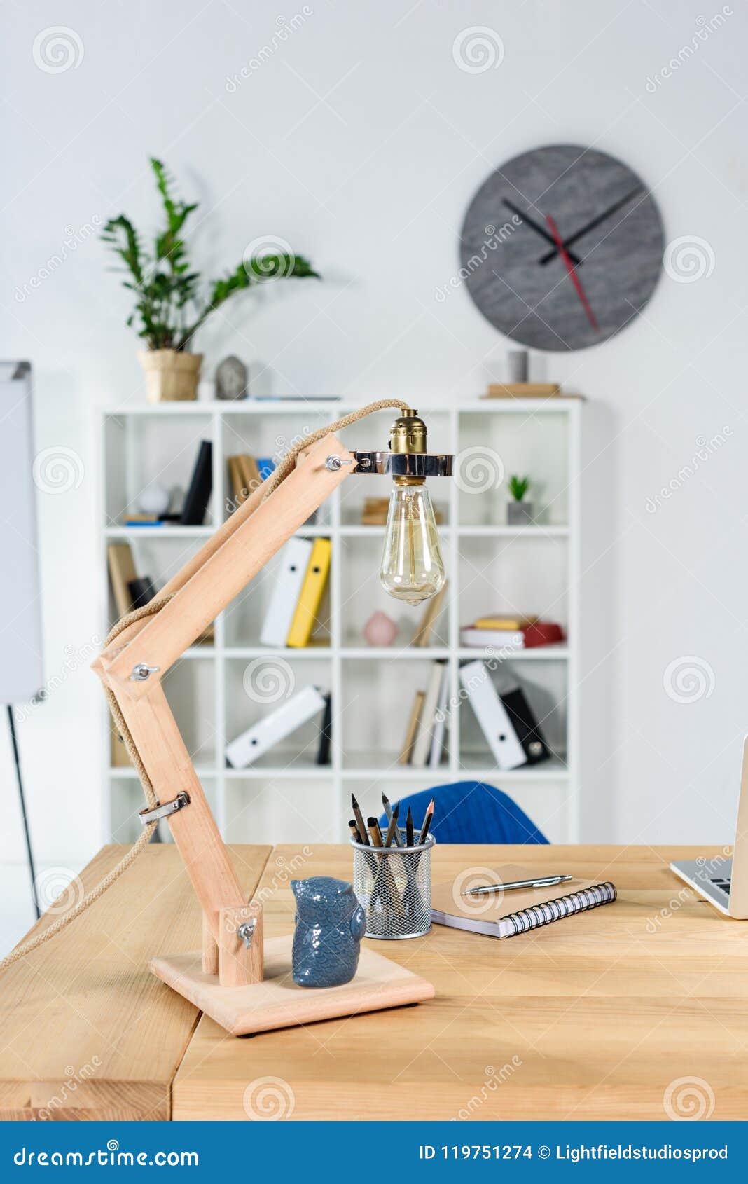 modern office interior with wooden table, desklamp and stationery placed