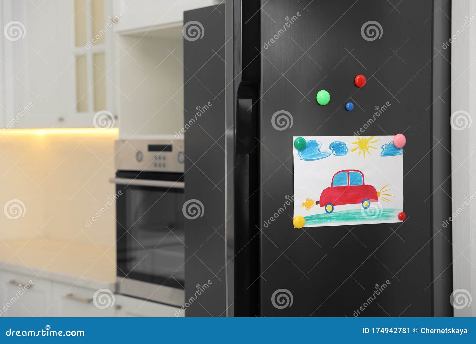Refrigerator with Child`s Drawing and in Kitchen Stock Image