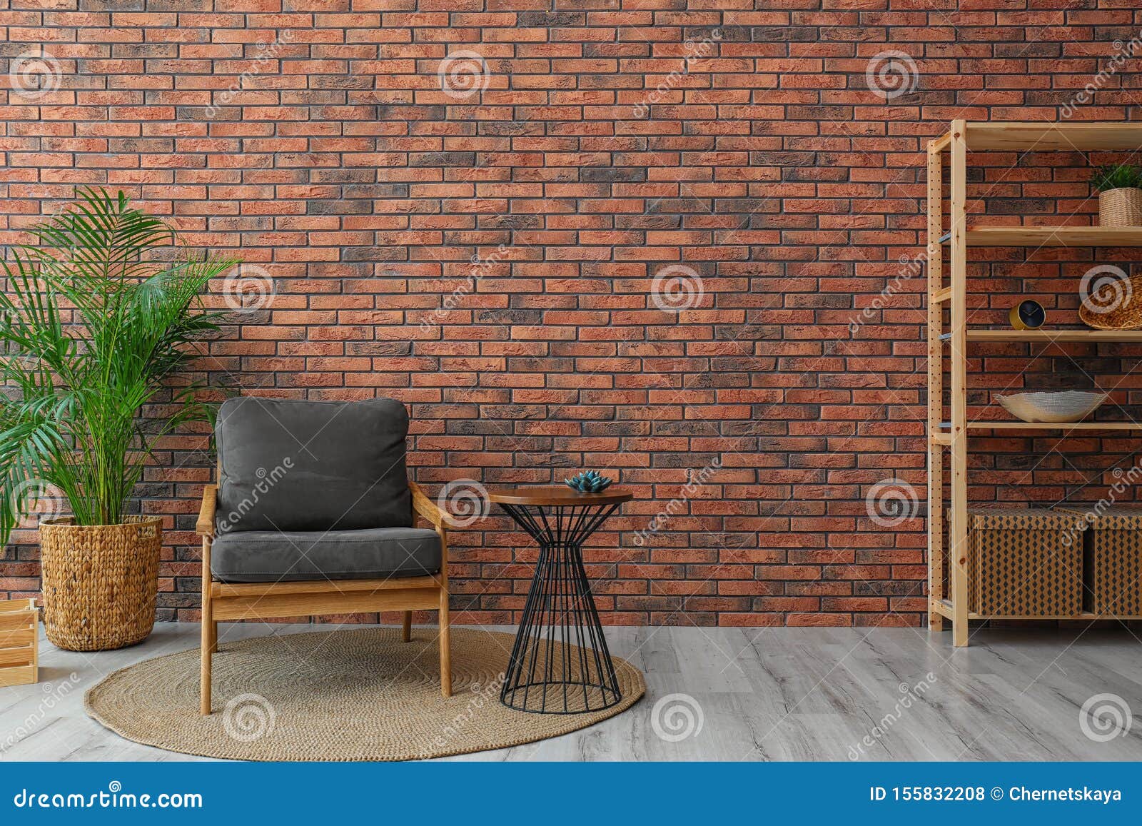 modern room interior with stylish grey  and potted plant near brick wall