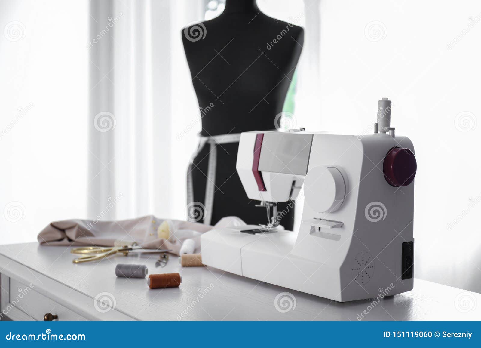 Modern Sewing Machine with Fabric and Tailor S Supplies on Table in
