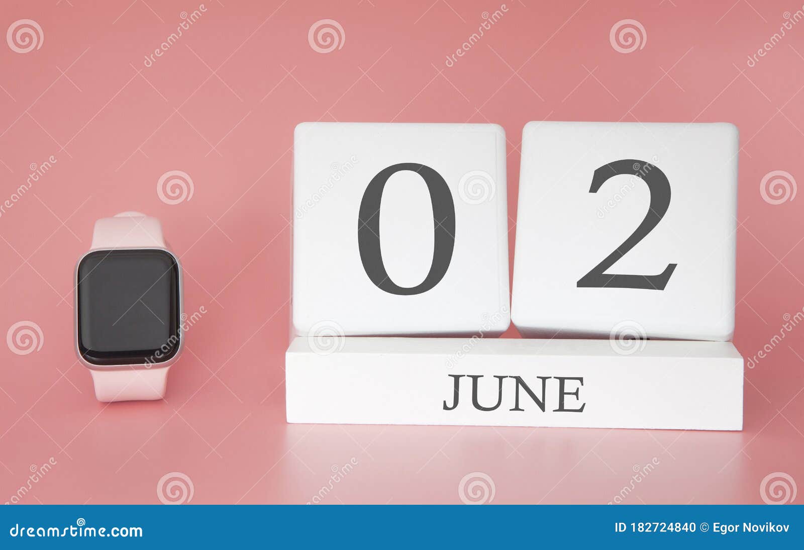 modern watch with cube calendar and date 02 june on pink background. concept summer time vacation