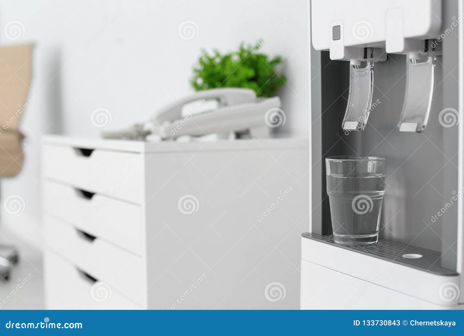 Modern Water Cooler with Glass in Office, Closeup. Stock Image Image