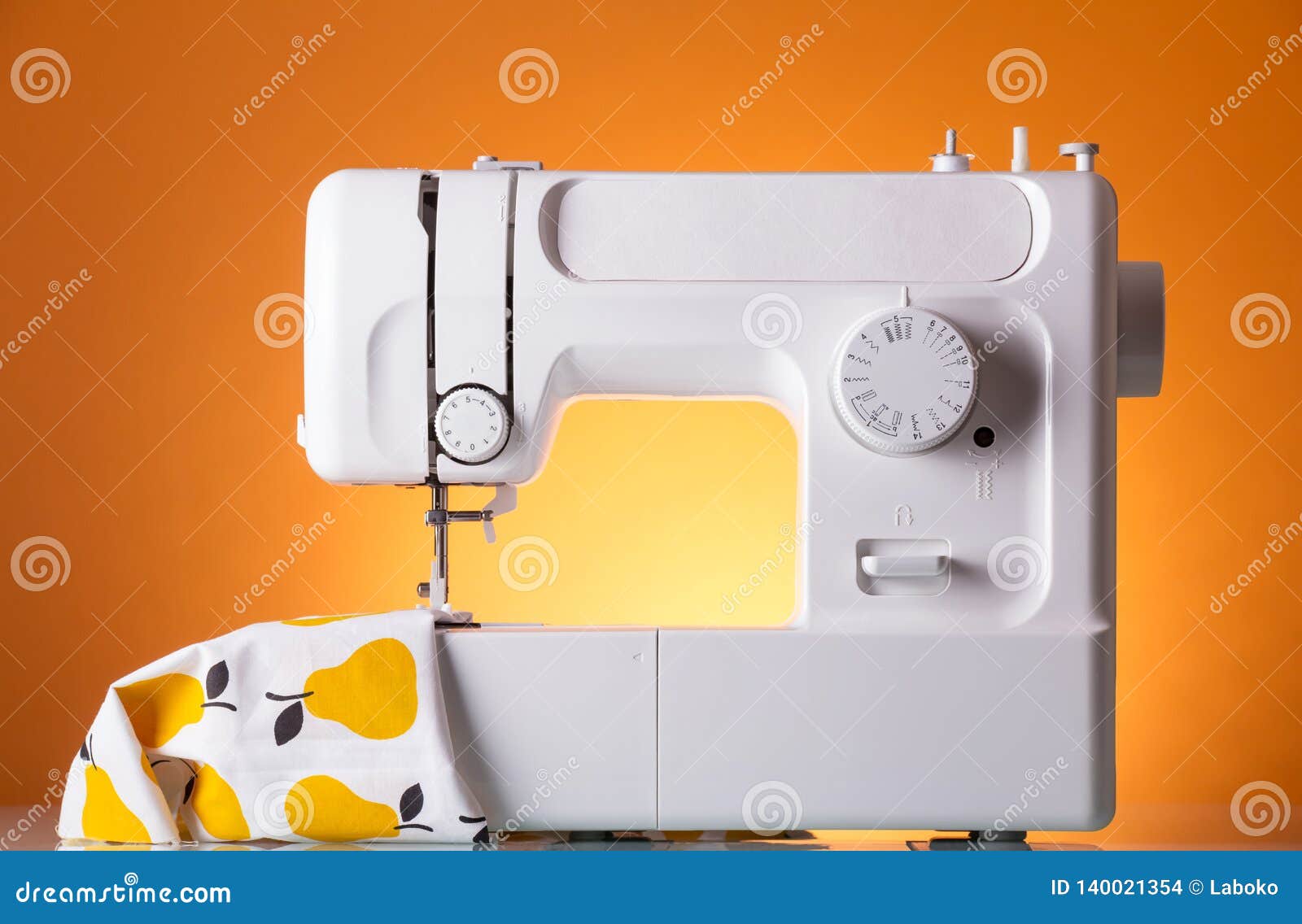Modern White Electric Sewing Machine with the Fabric on Bright Yellow