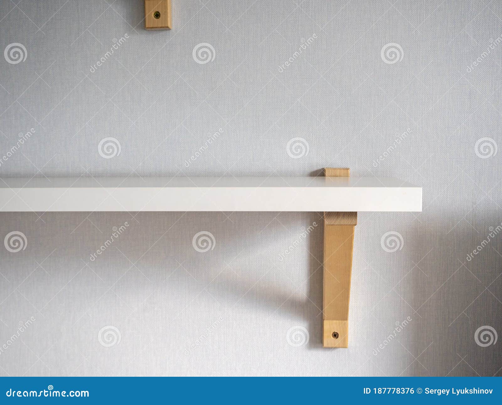 A Modern White Wooden Shelf Hangs on the Wall in the Room. Modern
