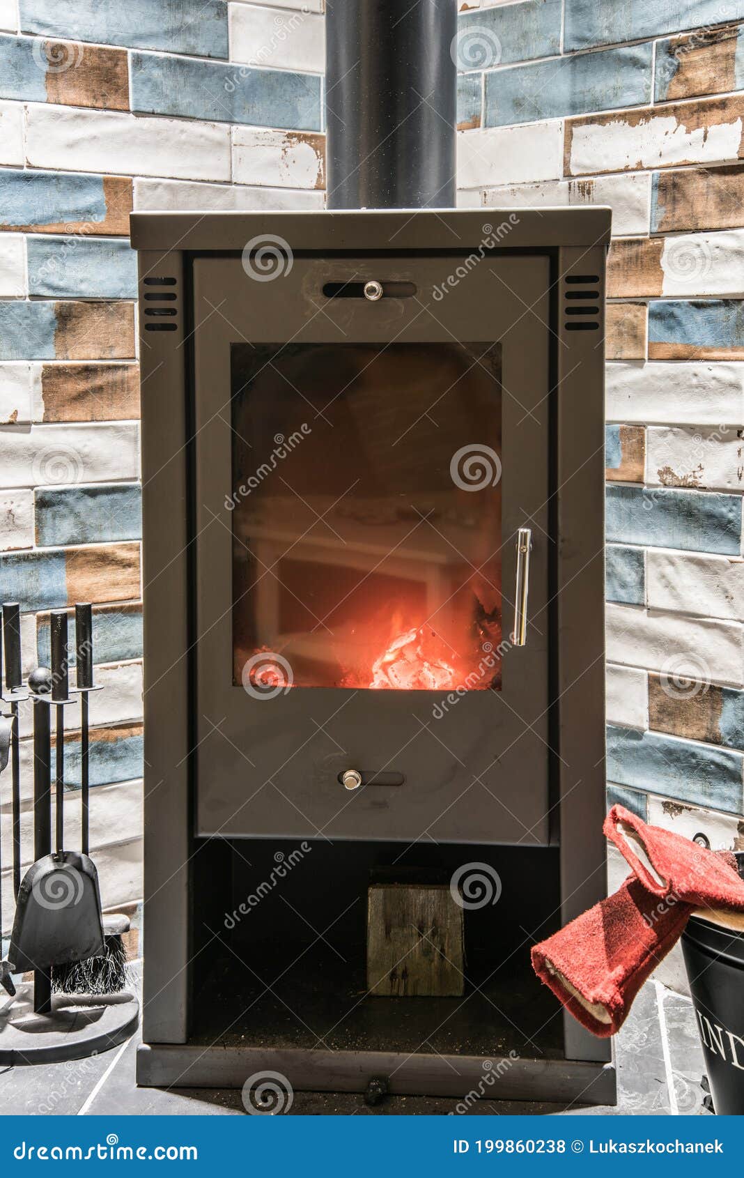 Modern Wood Burning Stove with Accessories and Red Gloves Next To