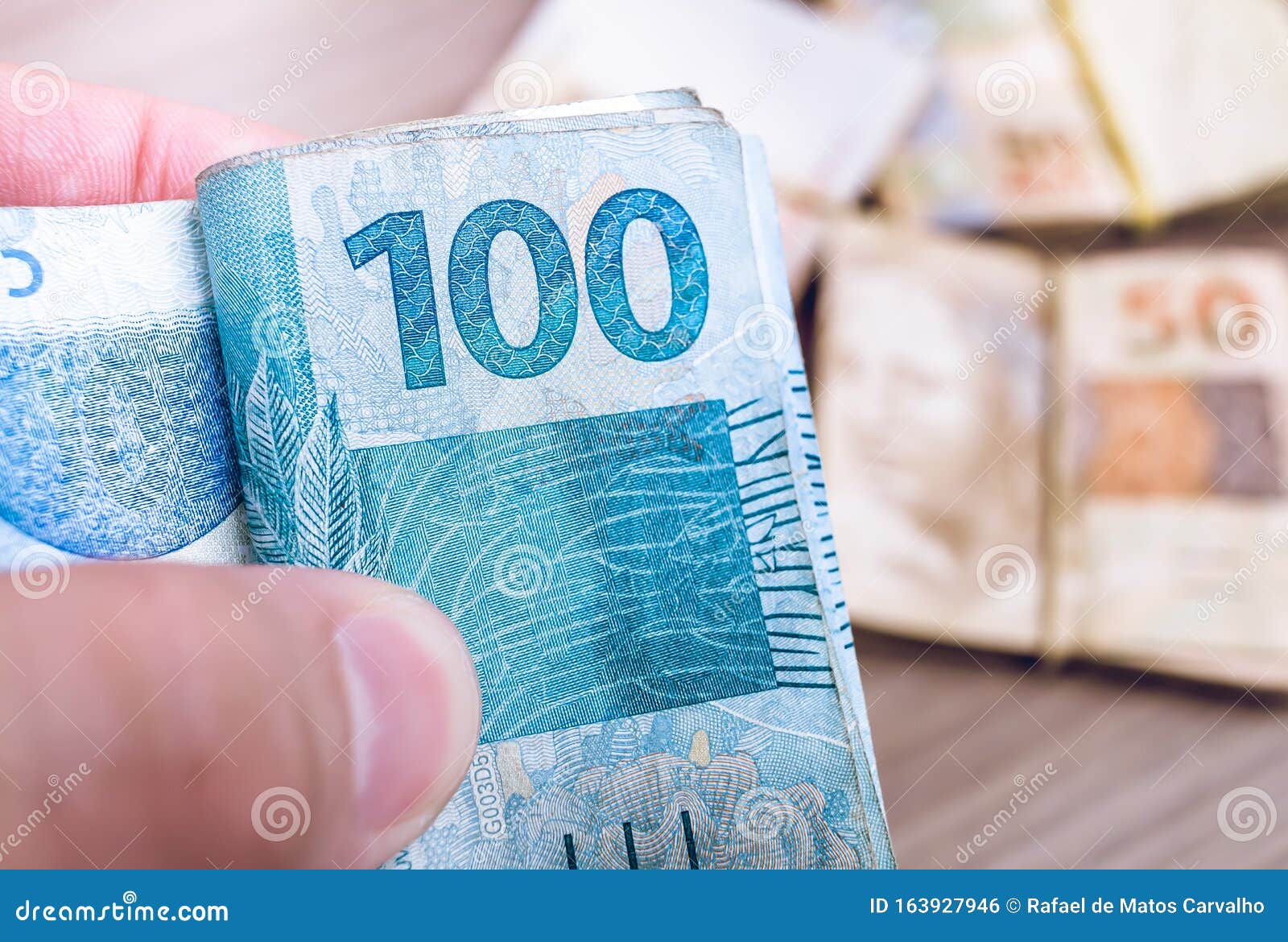 Dinheiro do Brasil, notas de Real, moeda brasileira. Na foto, homem  segurando notas de 50 reais Stock Photo - Alamy