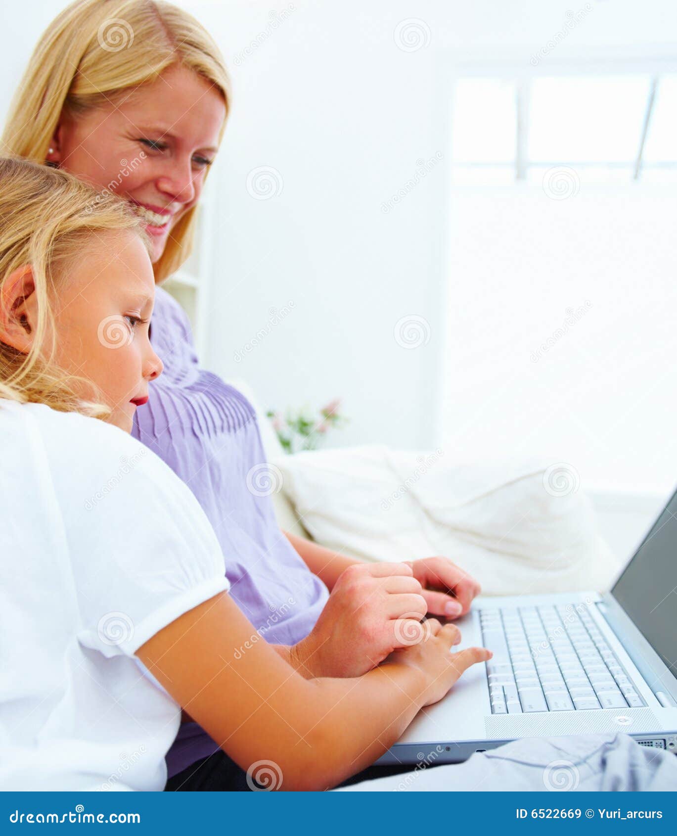 Gelukkige moeder en haar dochter die laptop met behulp van