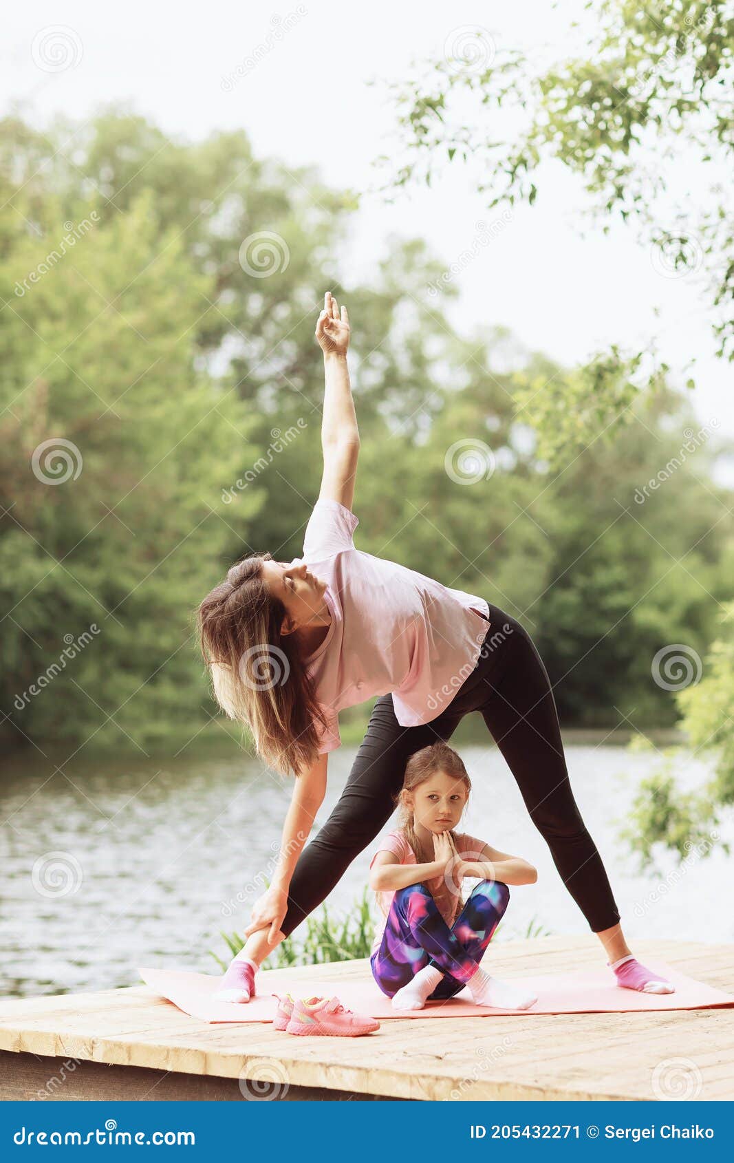 mom daughter practice yoga asanas wooden bridge near river warm sunny day healthy lifestyle concept mom 205432271