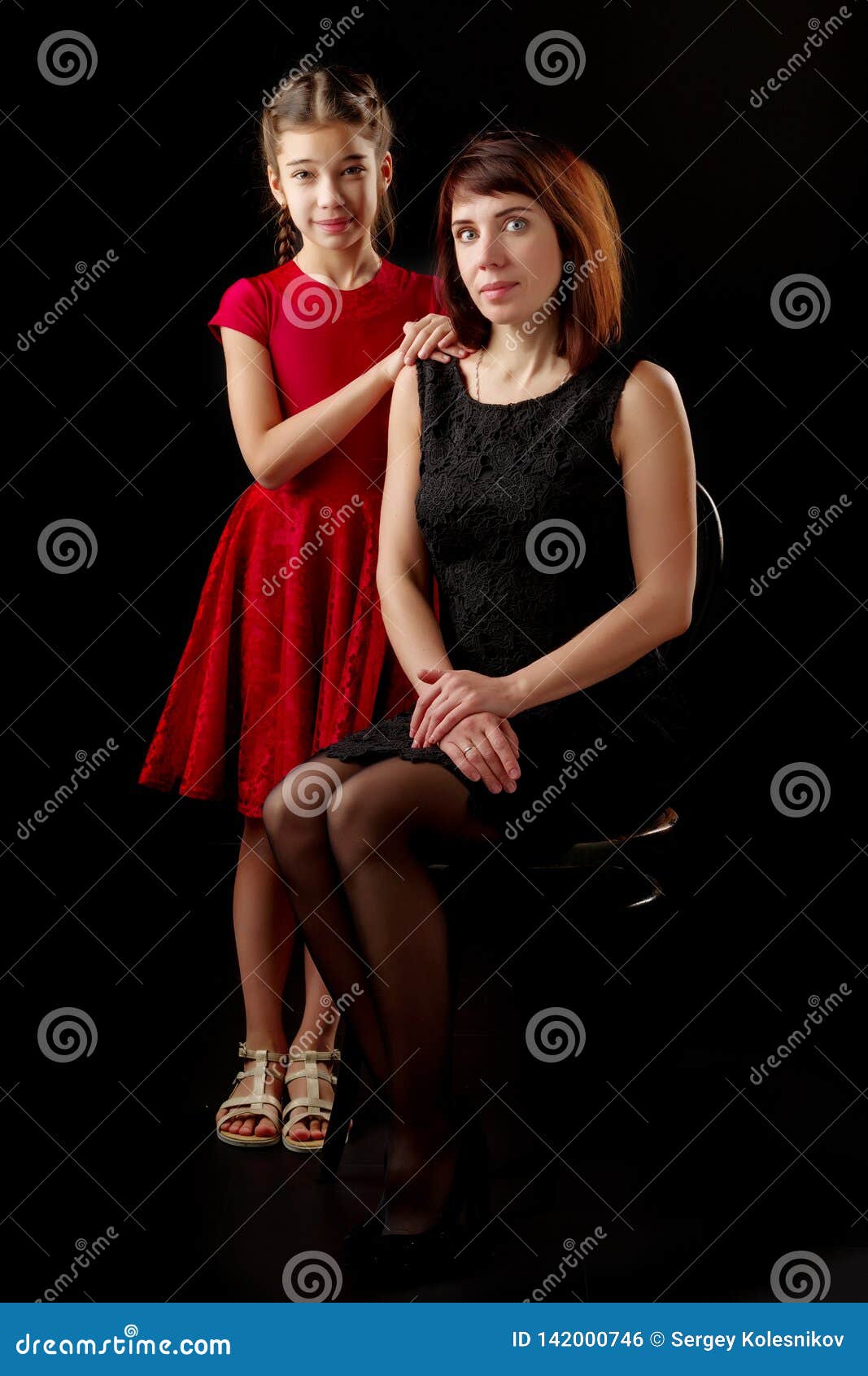 Mom and Daughter in the Studio on a Black Background. Stock Photo ...