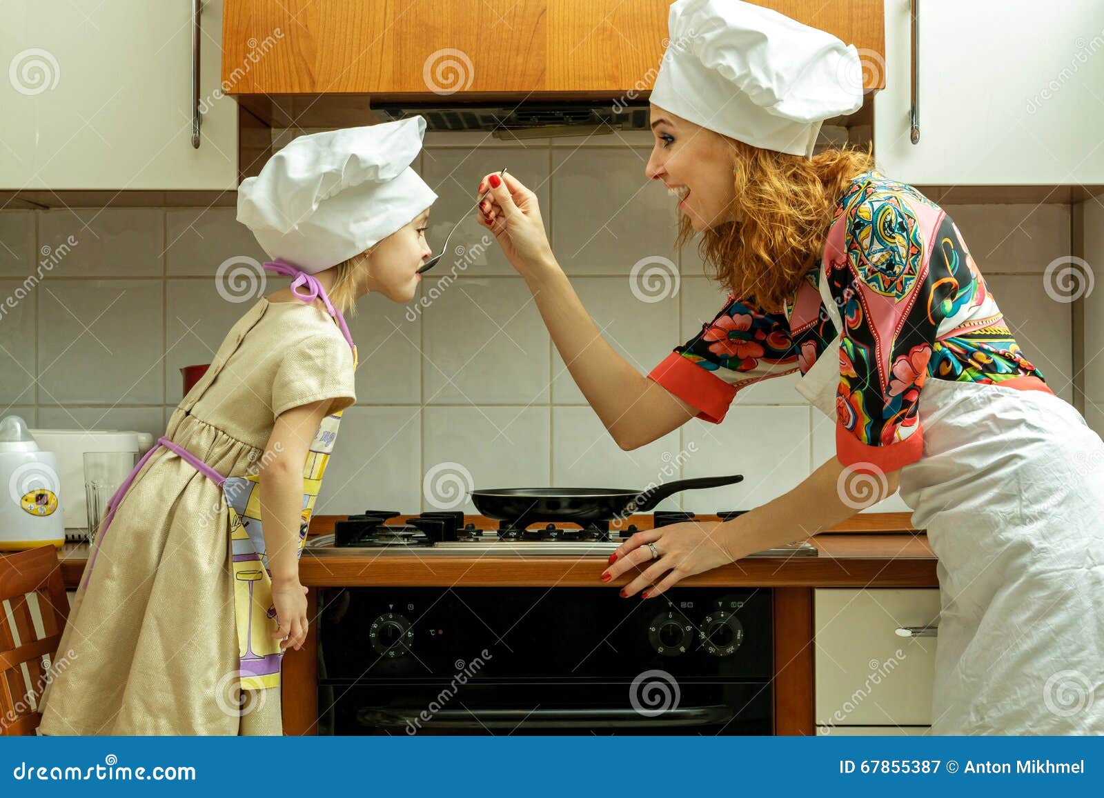 https://thumbs.dreamstime.com/z/mom-daughter-white-chef-hats-cook-kitchen-girl-tasting-food-67855387.jpg