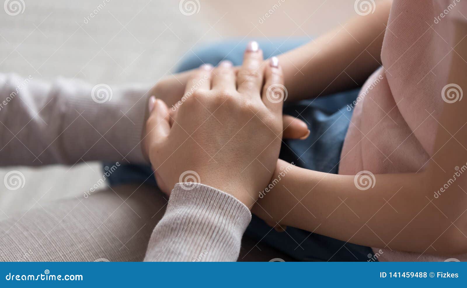 mom giving support trust to little daughter holding hands, closeup
