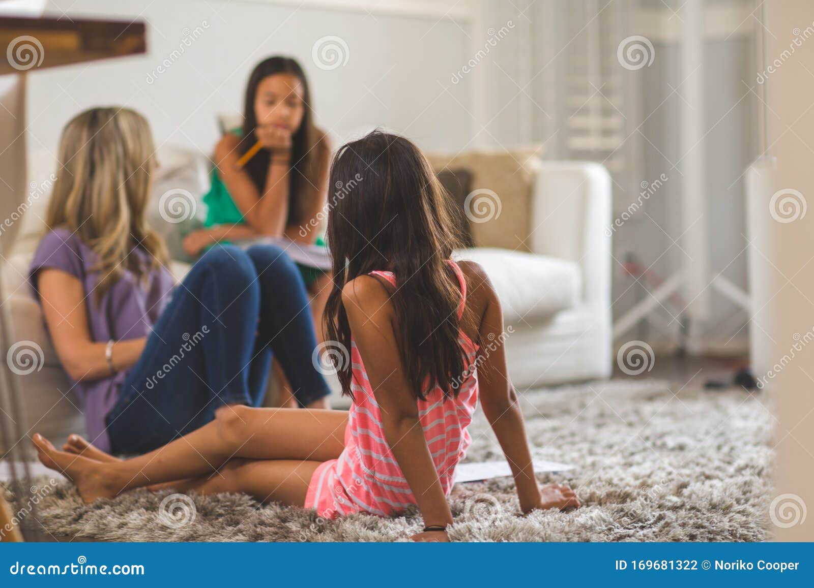 mother reading to her daughters and helping them with their homework