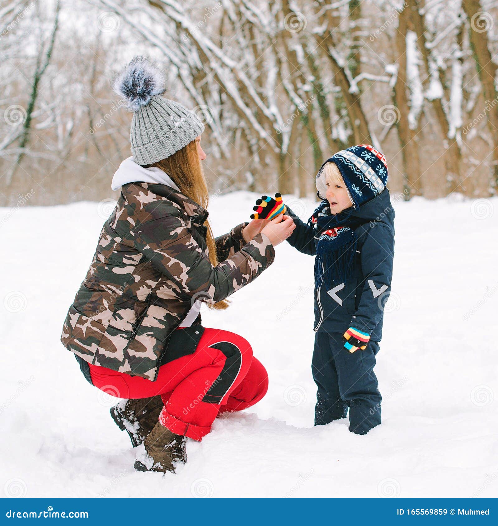 Mom Helps Her Son To Put on Gloves in Winter. Family on a Winter Walk ...