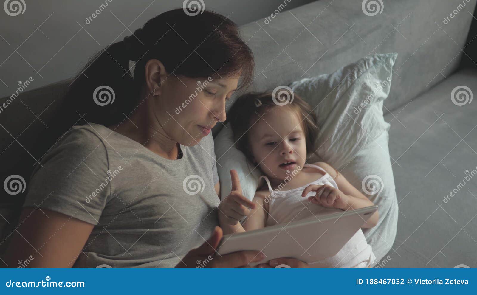 Mom and Little Daughter are Lying in Bed and Watching a Cartoon on a  Tablet. Mother and Baby Make a Video Call To Father Stock Photo - Image of  daughter, game: 188467032