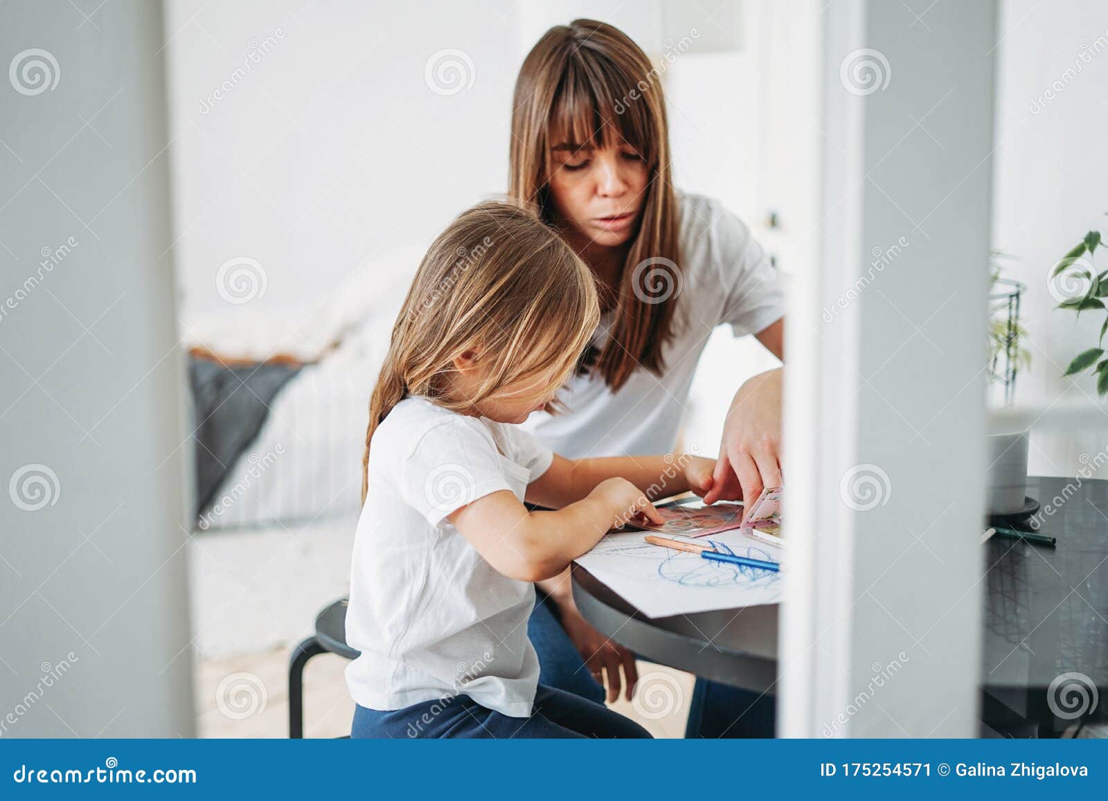 Mom And Daughter Working Together At Table At Home. Stock 