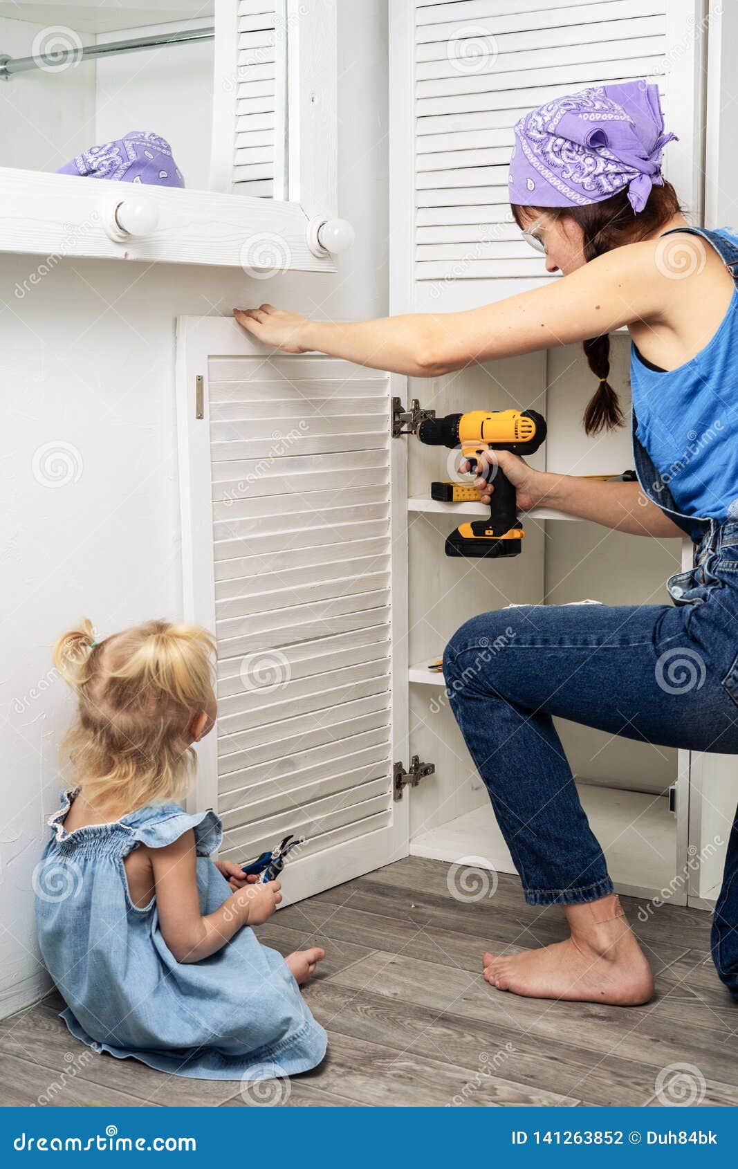 Mom Performs Men`s Work Mom And Daughter Hang The Door Of A White