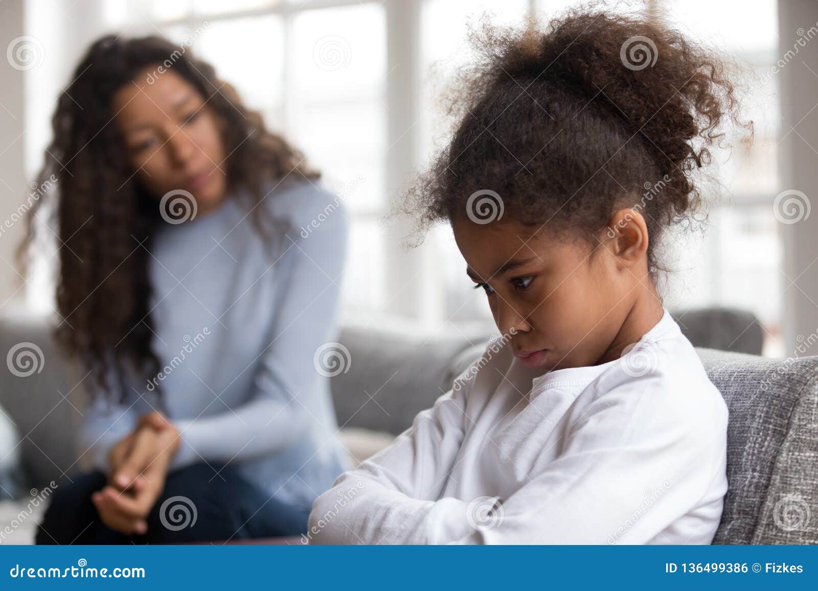 mom or psychologist tries to talk to upset african girl