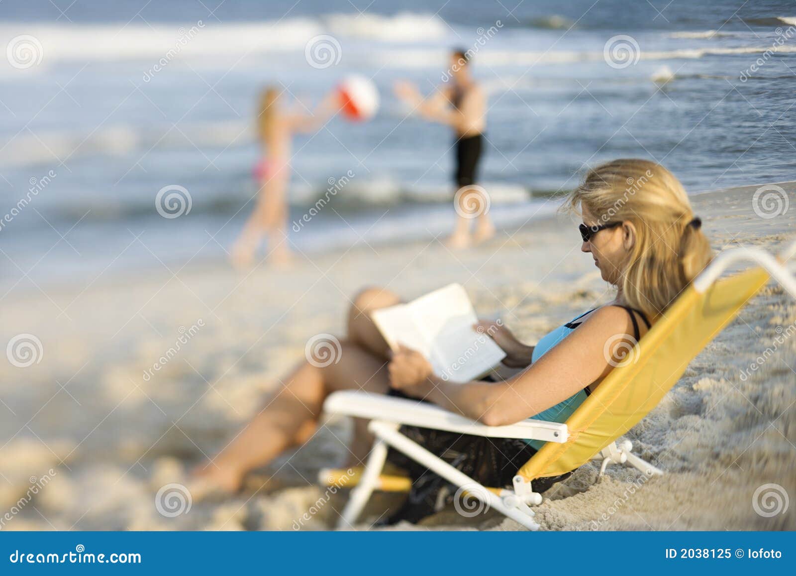 Mom Reading in Lounge Chair on Beach. Stock Image Image of island