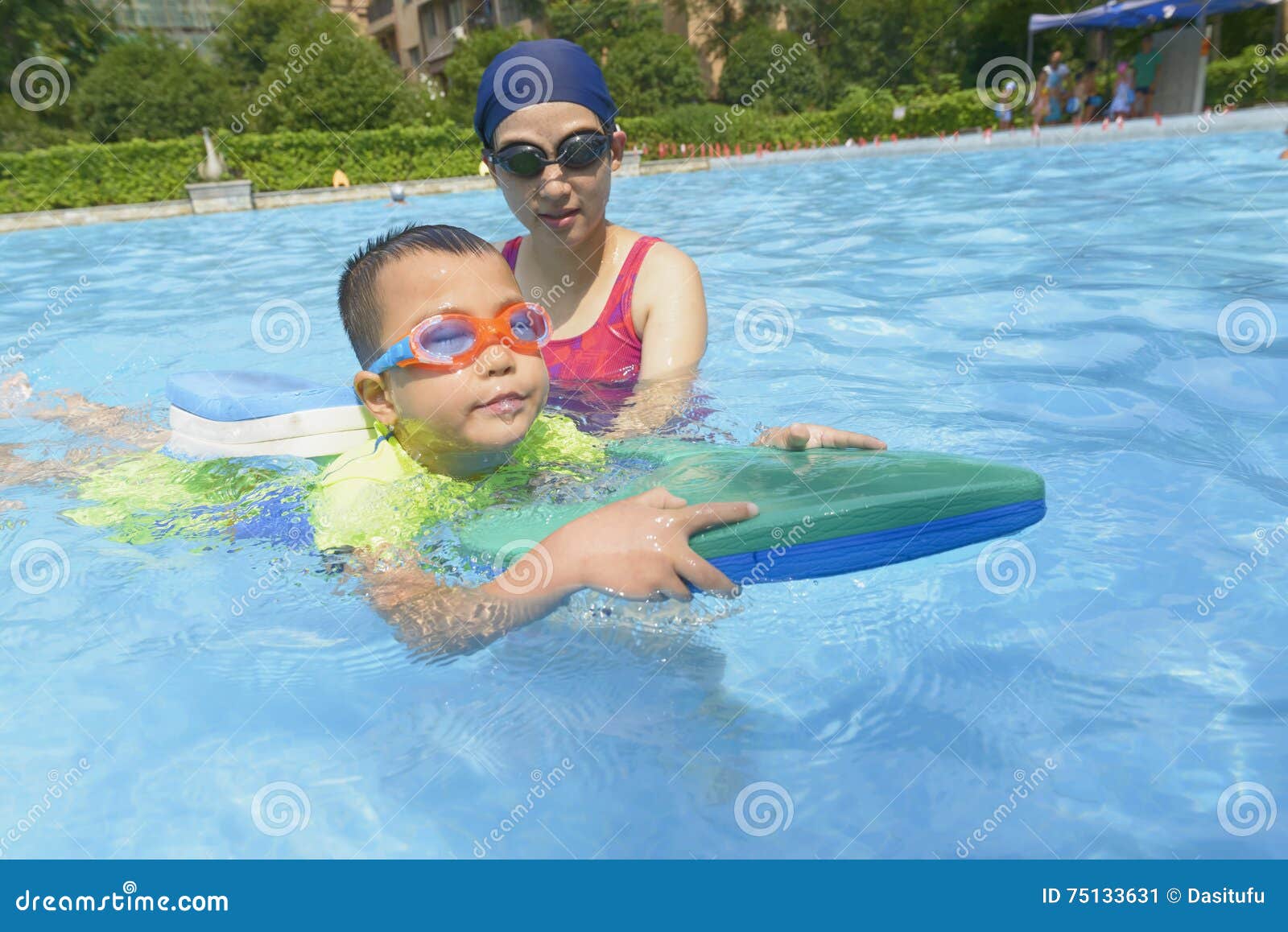 mom teaching son learn to swim in summer