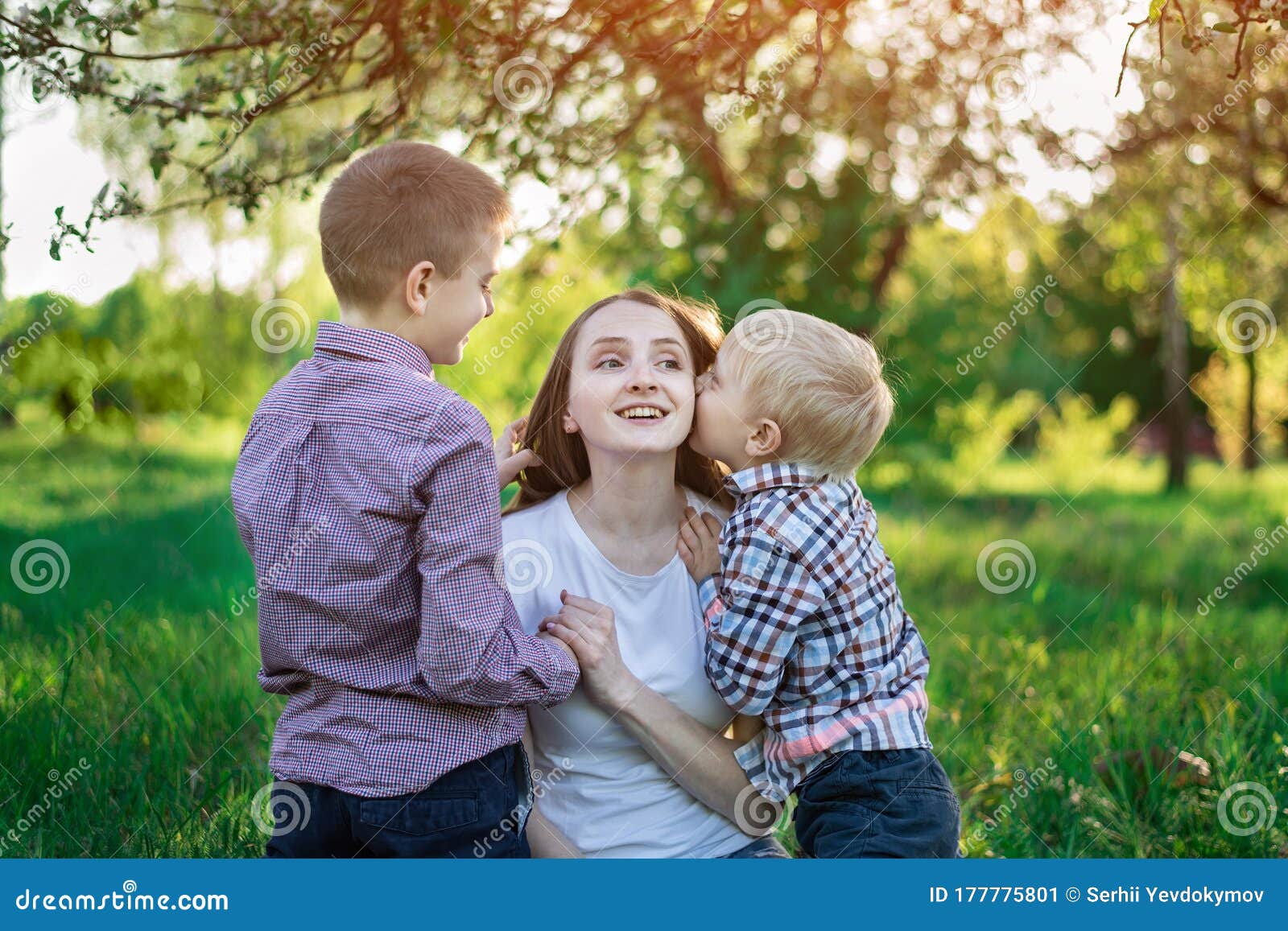 Mom With Two Sons In The Park Child Is Kissing His Mother Happy