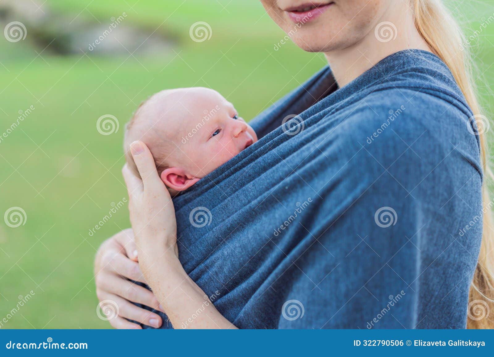 mom walks with her newborn baby in a sling. this moment highlights the close bond between mother and child, promoting