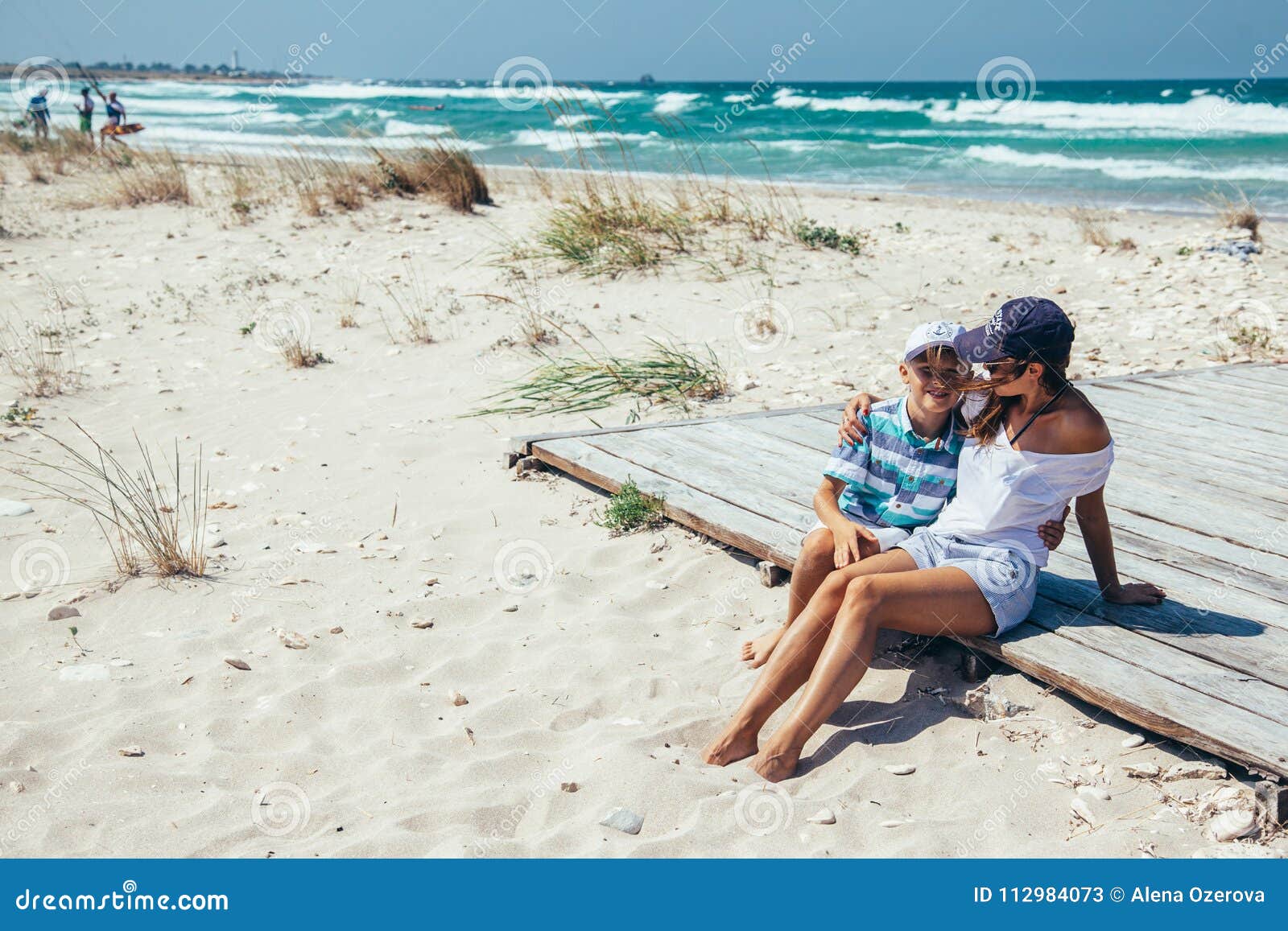 Mom and Son Relaxing and Hugging on the Beach Stock Image