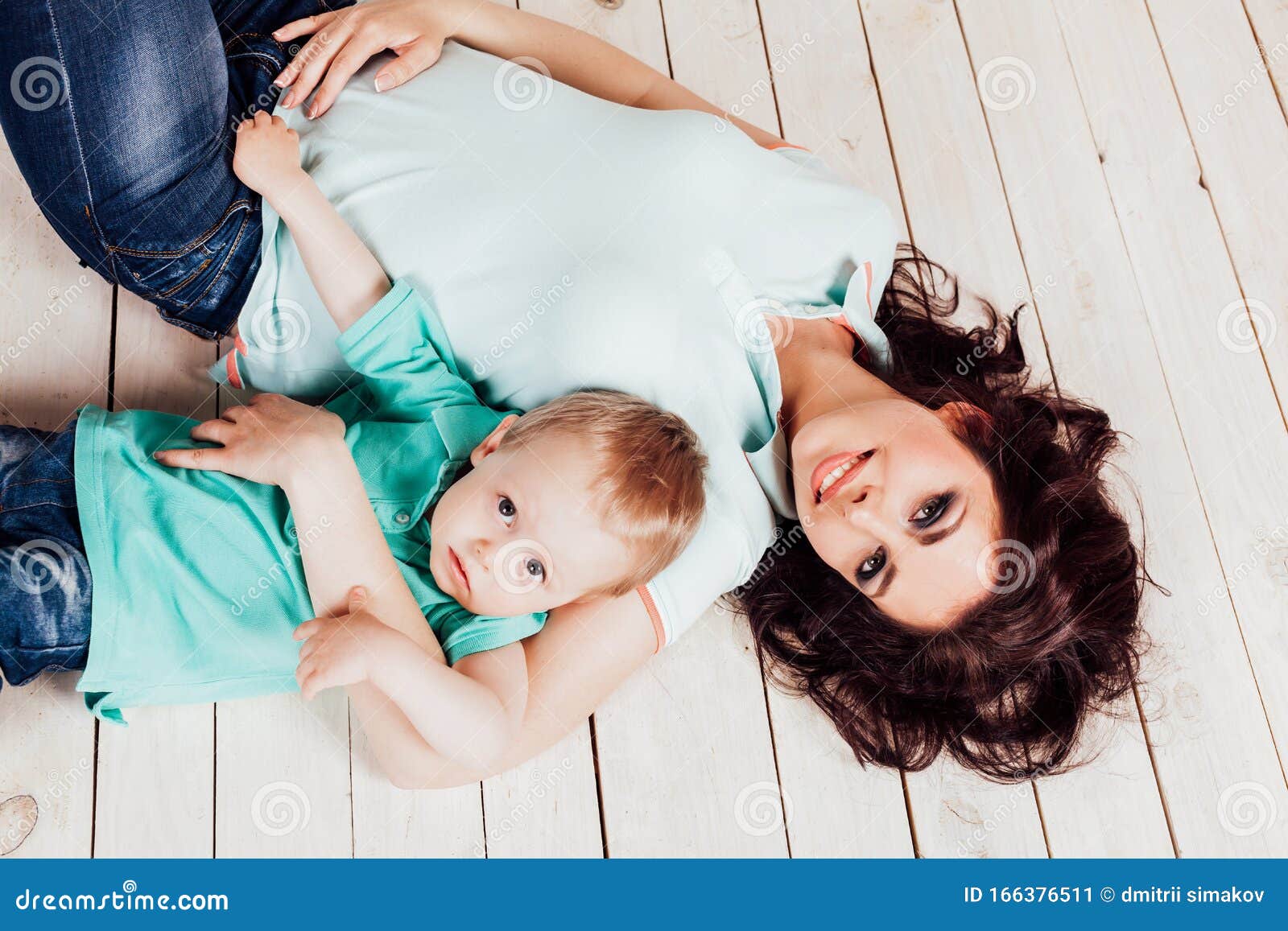 Mom And Young Boy Son Lying On The Wooden Floor Stock Image