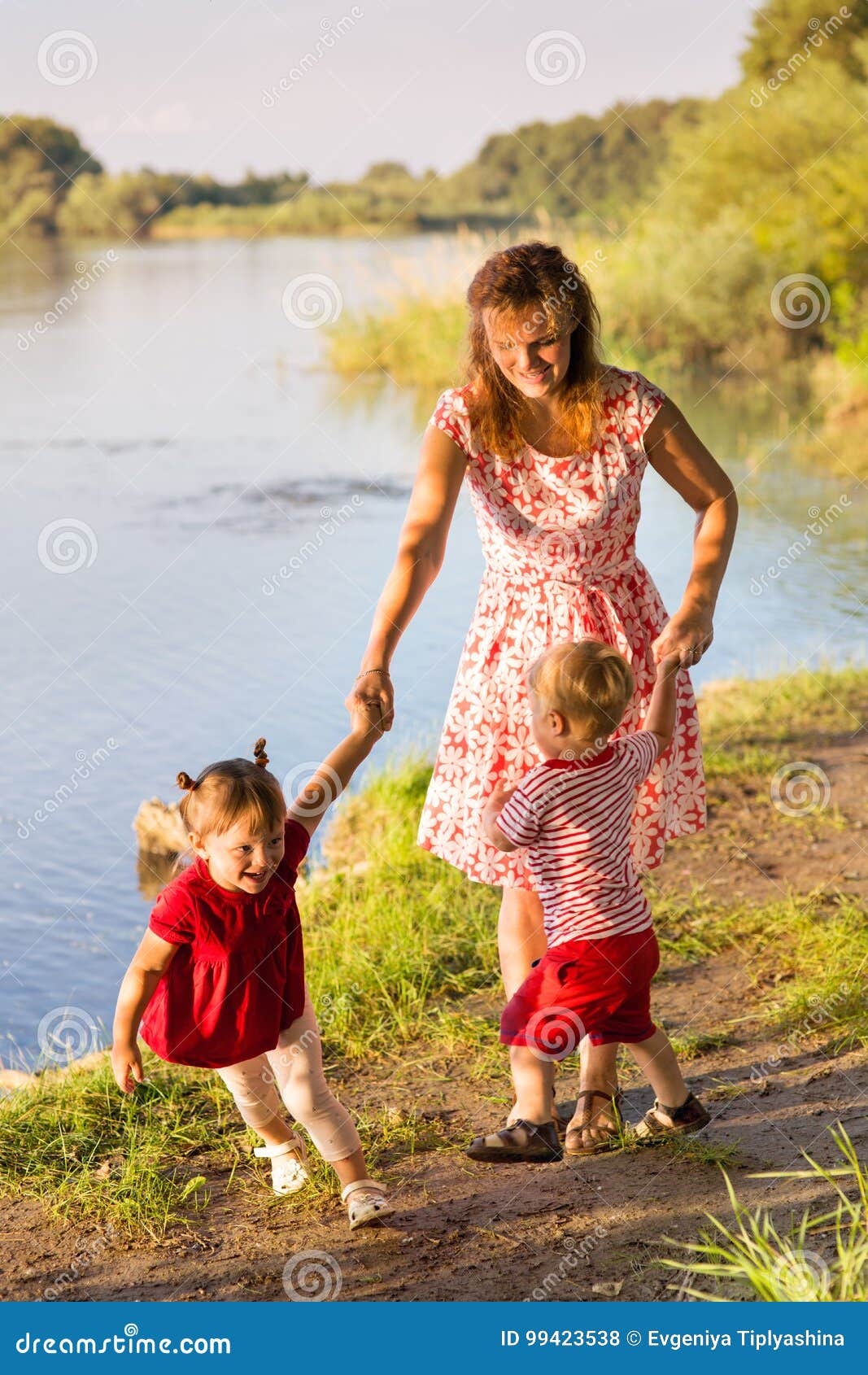 Mom με τα δίδυμα παιδιών στην όχθη ποταμού